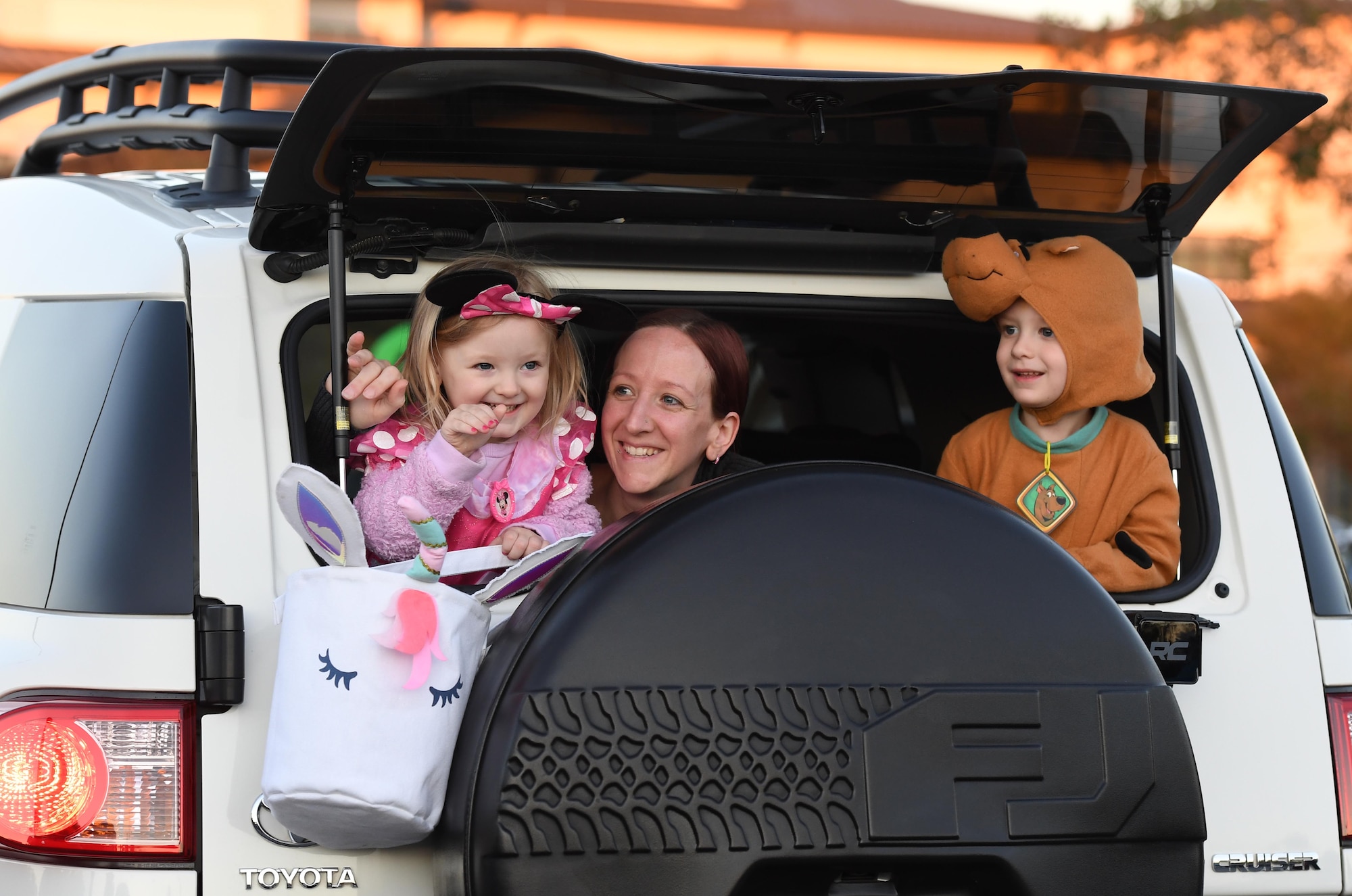 Ashley Norgard, spouse of U.S. Air Force Tech. Sgt. Richard Norgard, 334th Training Squadron instructor, and their children, Mila and Hanz, ride in the back of their truck during the Ghouls in the Park drive-thru event at the Bay Breeze Event Center parking lot at Keesler Air Force Base, Mississippi, Oct. 30, 2020. The 81st Force Support Squadron hosted the "trunk or treat" event for children of all ages. (U.S. Air Force photo by Kemberly Groue)