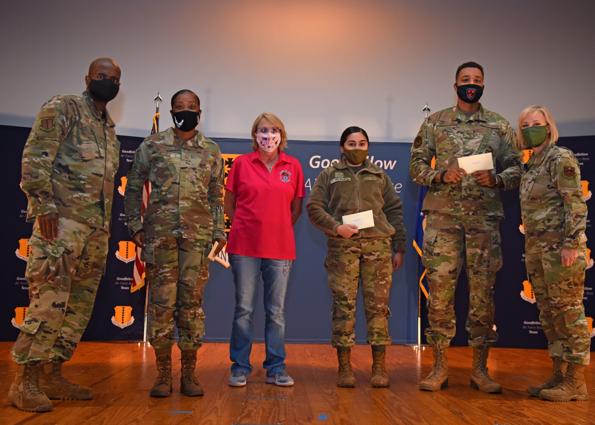 Members of Goodfellow are coined by U.S. Air Force Col. James Finlayson, 17th Training Wing vice commander, during the awards ceremony for the third quarter at the Base Theater on Goodfellow Air Force Base, Texas, Oct. 29, 2020. Individuals were recognized in front of the whole wing both in person and virtually. (U.S. Air Force photo by Airman 1st Class Ethan Sherwood)