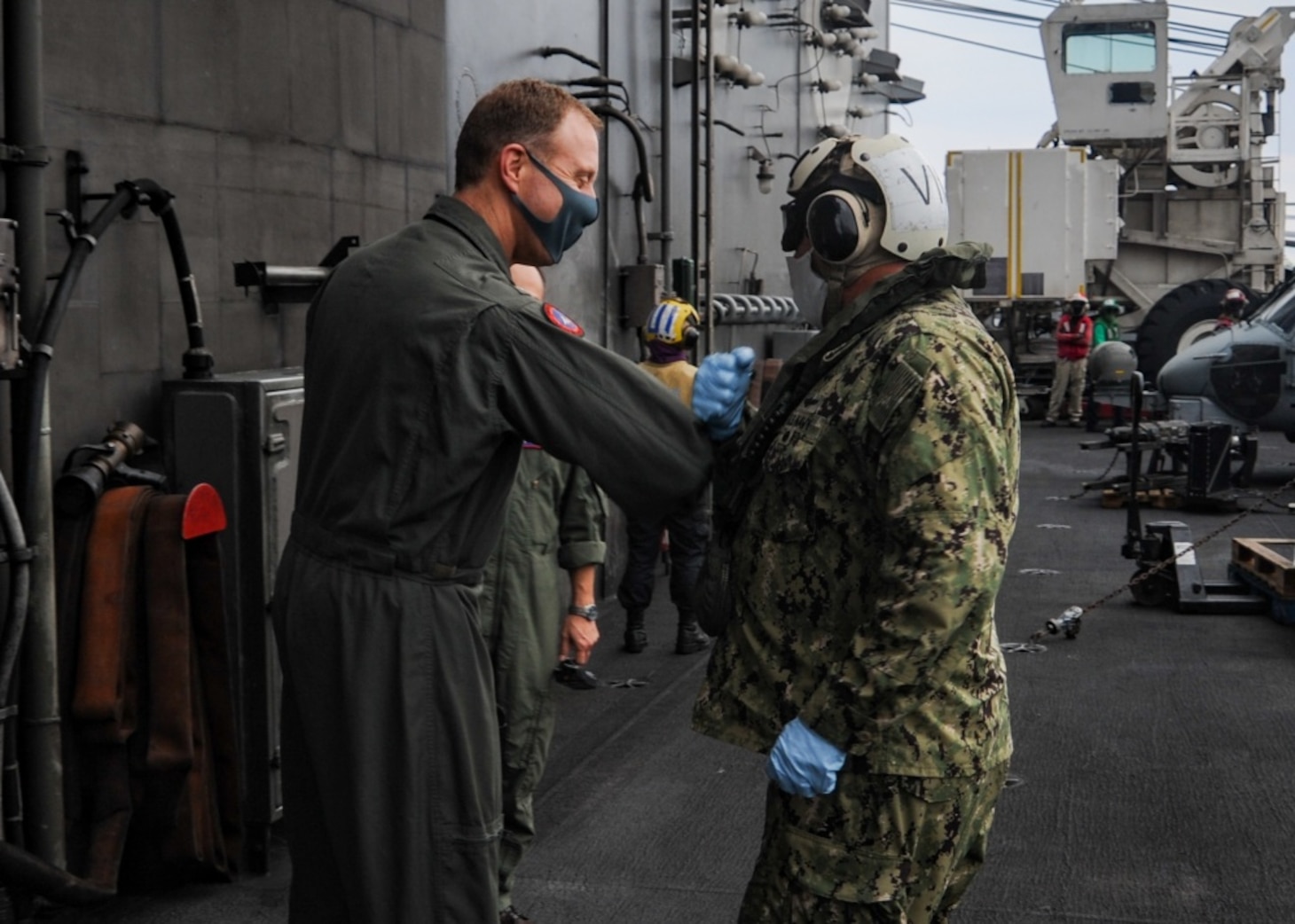 Rear Adm. George Wikoff greets Rear Adm. Will Pennington on the flight deck aboard America’s only forward-deployed aircraft carrier USS Ronald Reagan (CVN 76).