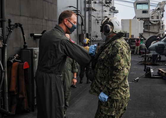 Rear Adm. George Wikoff greets Rear Adm. Will Pennington on the flight deck aboard America’s only forward-deployed aircraft carrier USS Ronald Reagan (CVN 76).