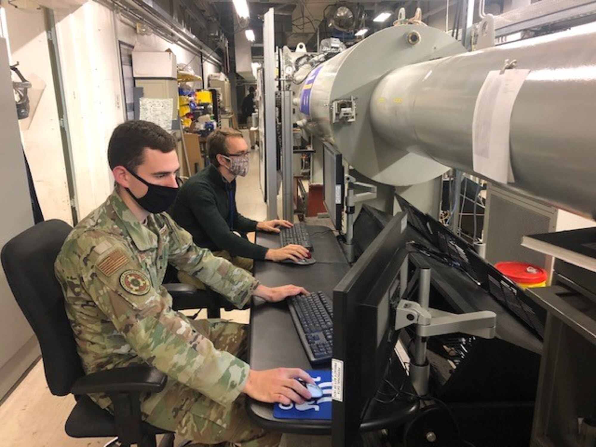 1st Lt. Tyler Despard (front) and Kameron Hayes monitor testing on the Supersonic Rain Erosion test rig. (U.S. Air Force photo/Greg Lanchman)