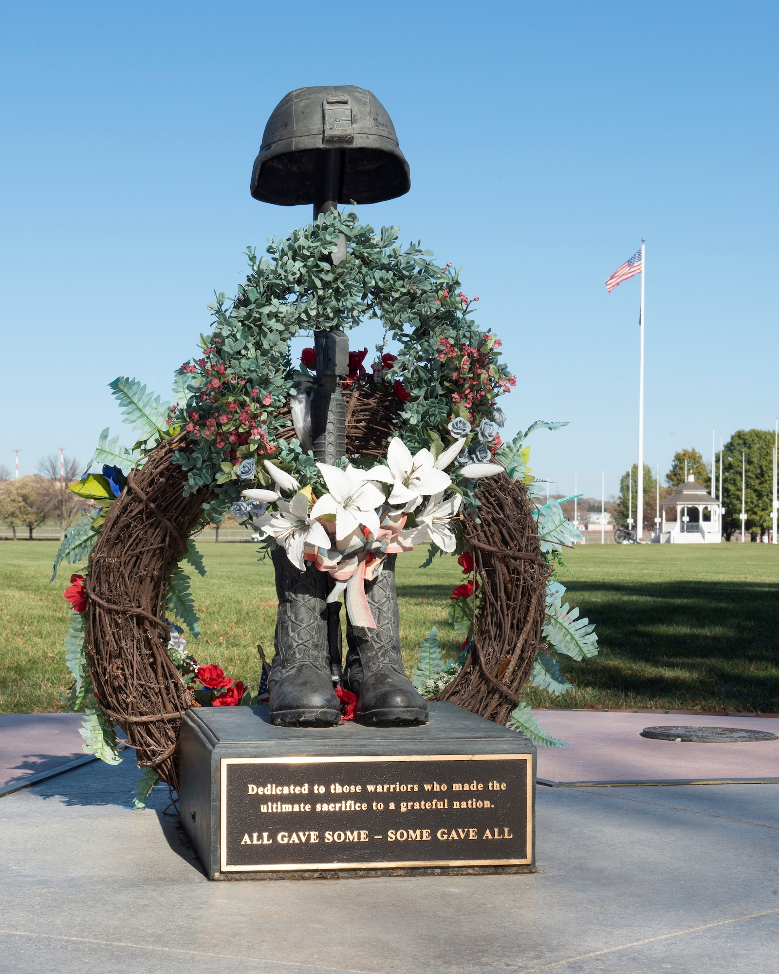 A memorial to fallen service members with the American Flag behind it.