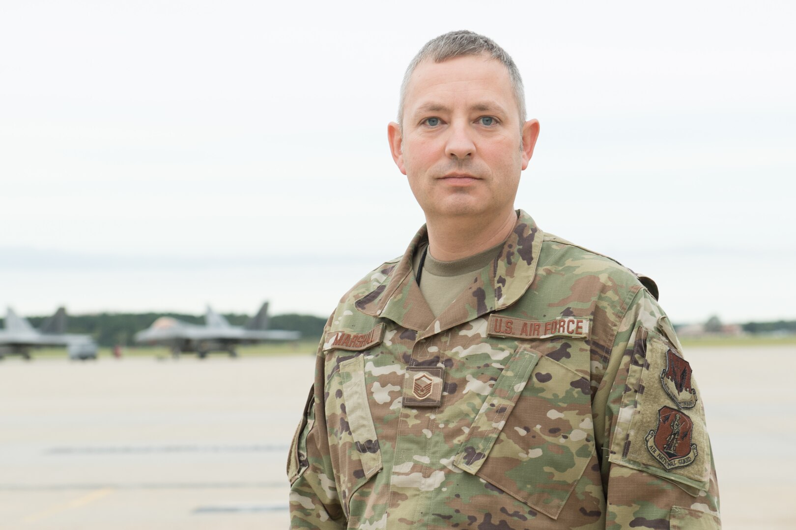 An Airman poses for a photo on the flight line