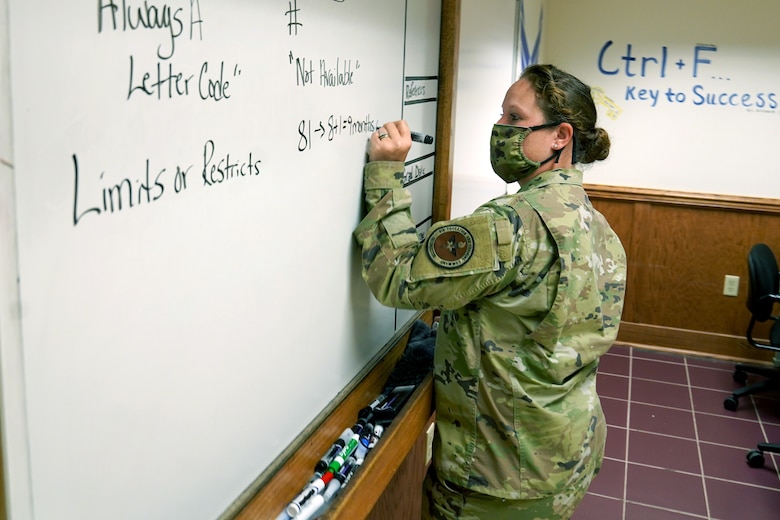 U.S. Air Force Tech. Sgt. Kathy Pool, 335th Training Squadron Personnel Apprentice Course instructor, writes class material on a whiteboard inside Wolfe Hall at Keesler Air Force Base, Mississippi, November 3, 2020. The 335th TRS tested the Direct to Duty Technical Training program on a class of prior-service students, aiming to save money and time, keep the students safe and healthy and allow them to stay with their families. (U.S. Air Force photo by Airman 1st Class Seth Haddix)