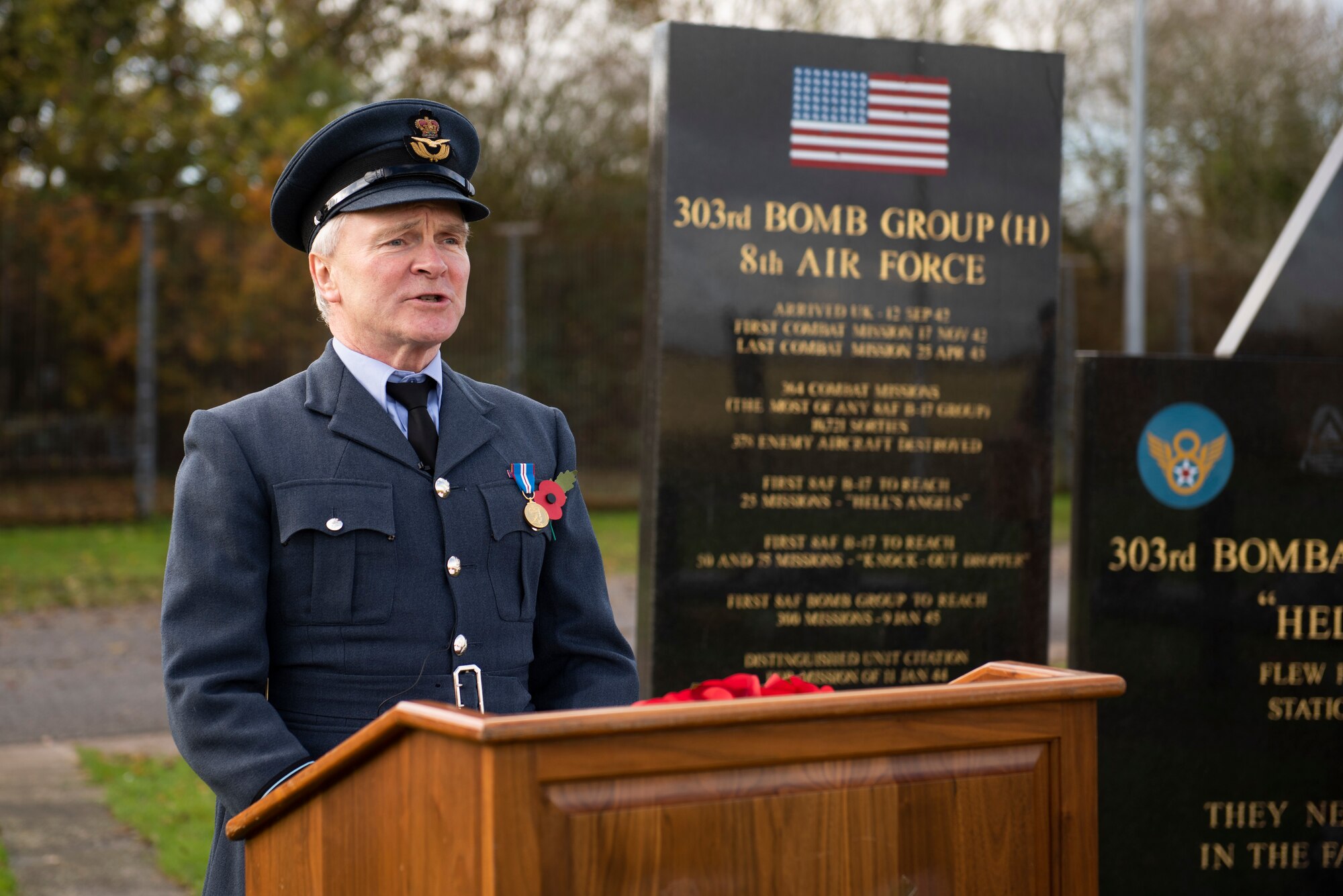 Royal Air Force Sqn. Ldr. Clive Wood, RAF Alconbury and RAF Molesworth RAF commander, reads an excerpt from the poem “For the Fallen,” by Robert Laurence Binyon, during a Remembrance Sunday ceremony near the 303rd Bombardment Group monument at RAF Molesworth, England, Nov. 3, 2020. Remembrance Sunday is commemorated the second Sunday every November to honor the service and sacrifice of Armed Forces, British and Commonwealth veterans, as well as the Allies that fought alongside them in the two World Wars and later conflicts. (U.S. Air Force photo by Senior Airman Jennifer Zima)