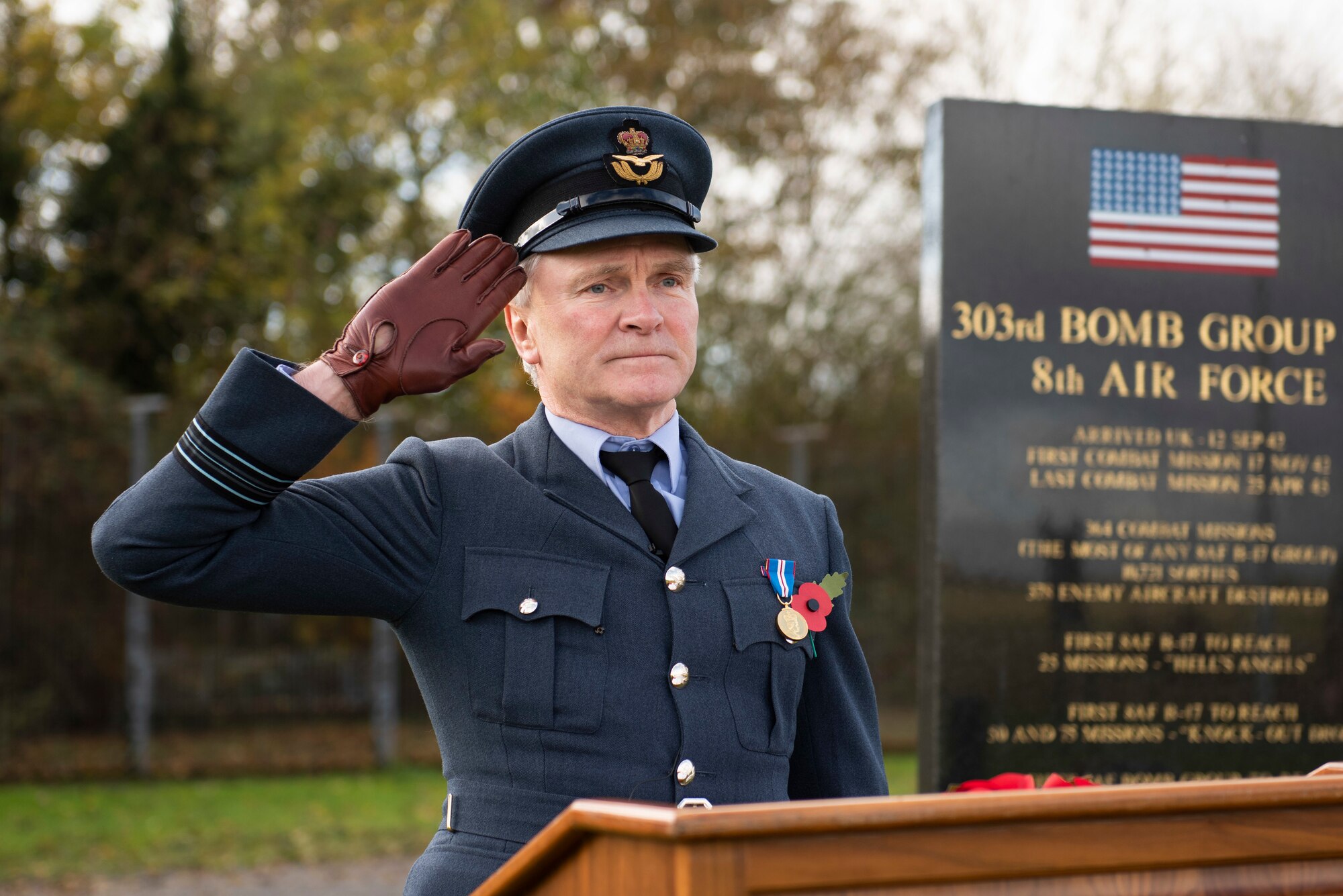 Royal Air Force Sqn. Ldr. Clive Wood, RAF Alconbury and RAF Molesworth RAF commander, salutes during a Remembrance Sunday ceremony near the 303rd Bombardment Group memorial monument at RAF Molesworth, England, Nov. 3, 2020. Remembrance Sunday is commemorated the second Sunday every November to honor the service and sacrifice of Armed Forces, British and Commonwealth veterans, as well as the Allies that fought alongside them in the two World Wars and later conflicts. (U.S. Air Force photo by Senior Airman Jennifer Zima)