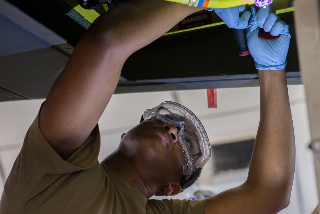U.S. Air Force Airman 1st Class Raymond Whitton, 380th Expeditionary Aircraft Maintenance Squadron crew chief, removes a fuel filter from an RQ-4 Global Hawk unmanned aerial vehicle at Al Dhafra Air Base, United Arab Emirates, Nov. 3, 2020.