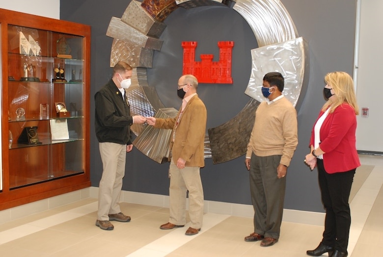 Principal Deputy Assistant Secretary of the Army for Installations, Energy and Environment Bryan Gossage presents a coin to U.S. Army Engineer Research and Development Center, Construction Engineering Research Laboratory (CERL), civil engineer James (Jim) Allen, while CERL Acting Director Dr. Kirankumar Topudurti and CERL Acting Deputy Director Michelle Hanson observe at the CERL in Champaign, Ill., Oct. 30, 2020. Allen was recognized for his outstanding support to IE&E and his work on autonomous vehicles. Allen’s efforts are helping the Army learn how to evaluate autonomous vehicle technologies to increase installation readiness, resiliency and quality of life.