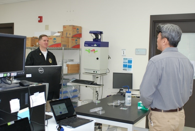 U.S. Army Engineer Research and Development Center, Construction Engineering Research Laboratory (CERL), chemist Dr. Kyoo Jo briefs the Principal Deputy Assistant Secretary of the Army for Installations, Energy and Environment Bryan Gossage on the lab’s research efforts related to synthetic biology at the CERL in Champaign, Ill., Oct. 30, 2020.