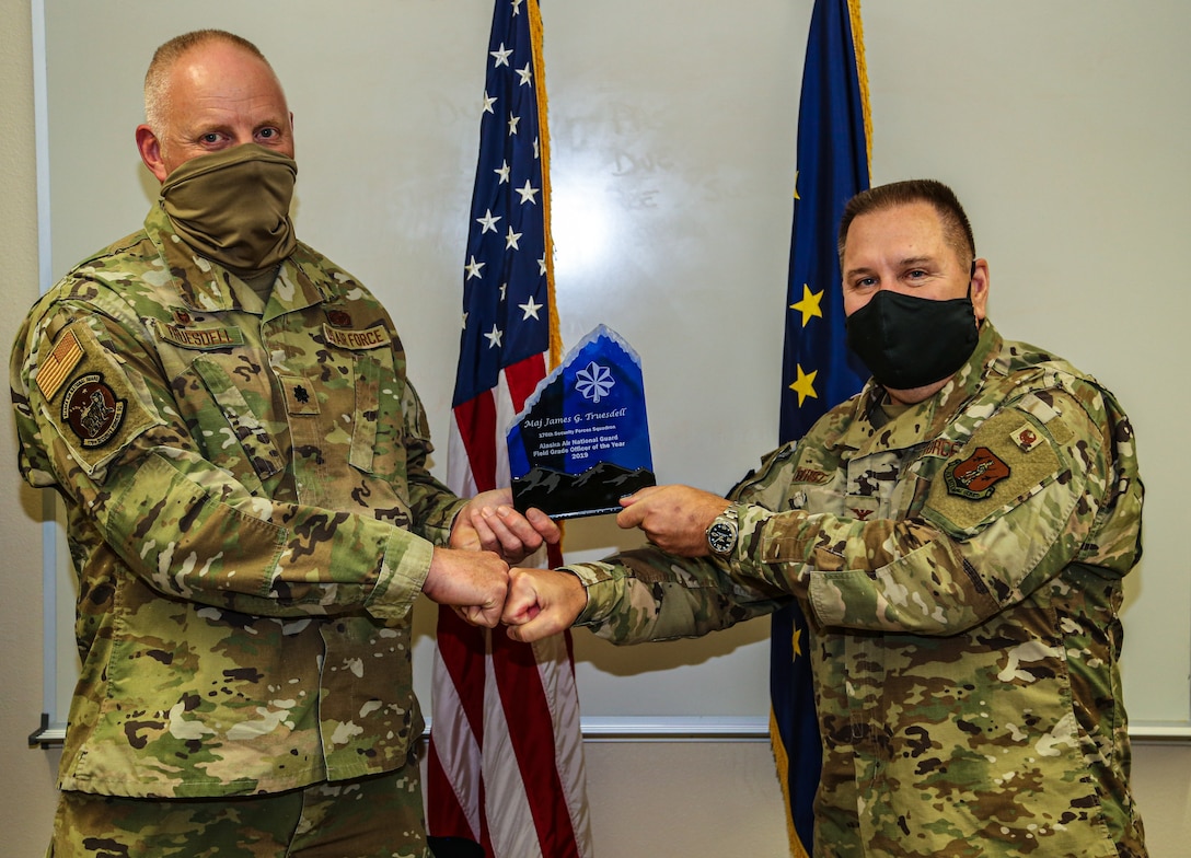 Col. John Oberst, director of staff for the Alaska Air National Guard, presents the Alaska Air Guard award for 2019 Field Grade Officer of the Year to Lt. Col. James Truesdell, the commander of the 176th Security Forces Squadron for his leadership accomplishments in 2019 at the 176th Wing Headquarters on Joint Base Elmendorf-Richardson, Sept. 15, 2020. Truesdell is also a retired Alaska State Trooper. He played a pivotal role in the success of his unit’s deployment to Afghanistan in 2019 in support of Operation Enduring Freedom. (U.S. Army National Guard photo by Sgt. Seth LaCount/Released)