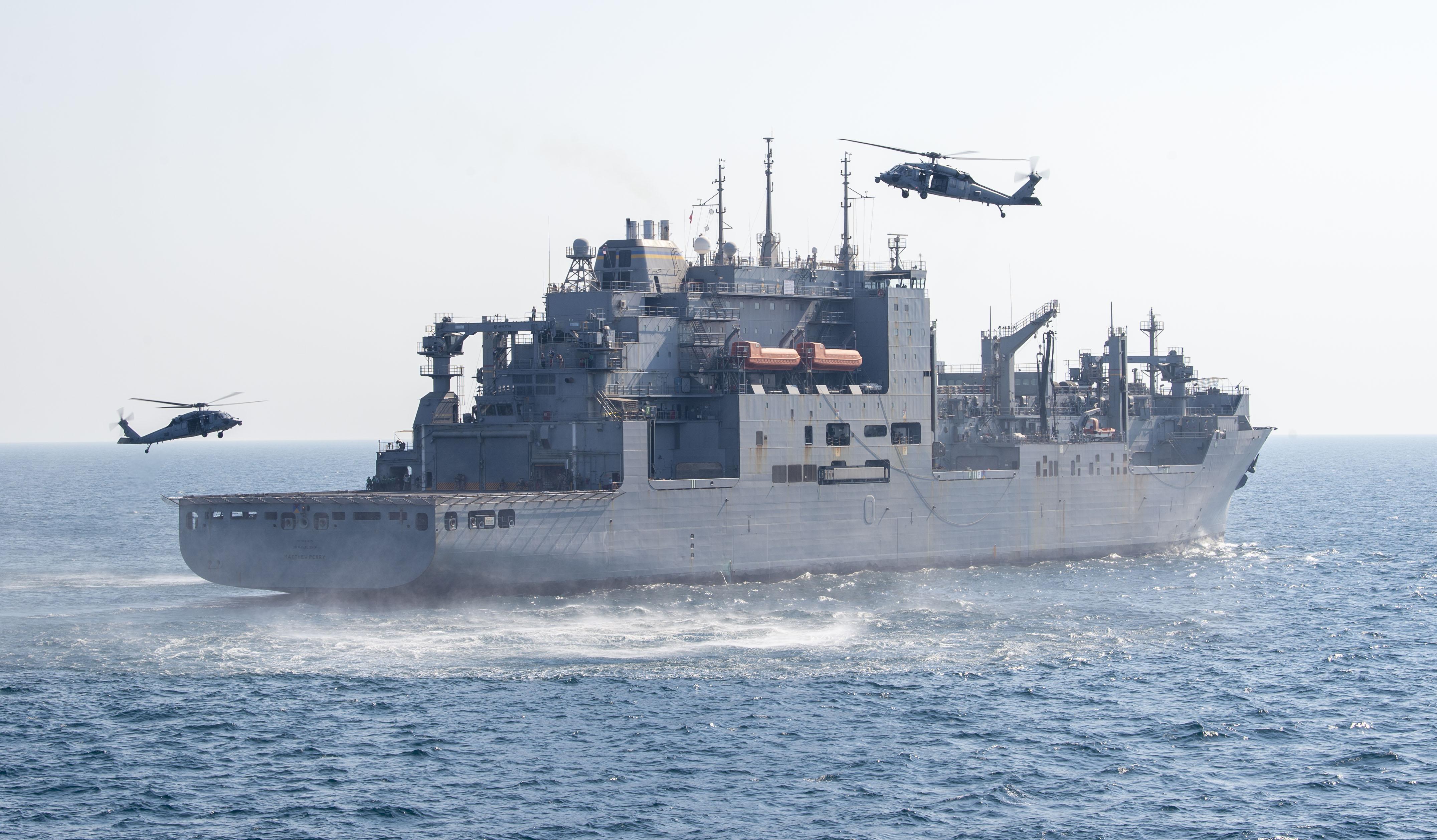 MH-60S Sea Hawk helicopters hover over USNS Matthew Perry (T-AKE 9) during a joint boarding exercise in the U.S. 5th Fleet area of operations.