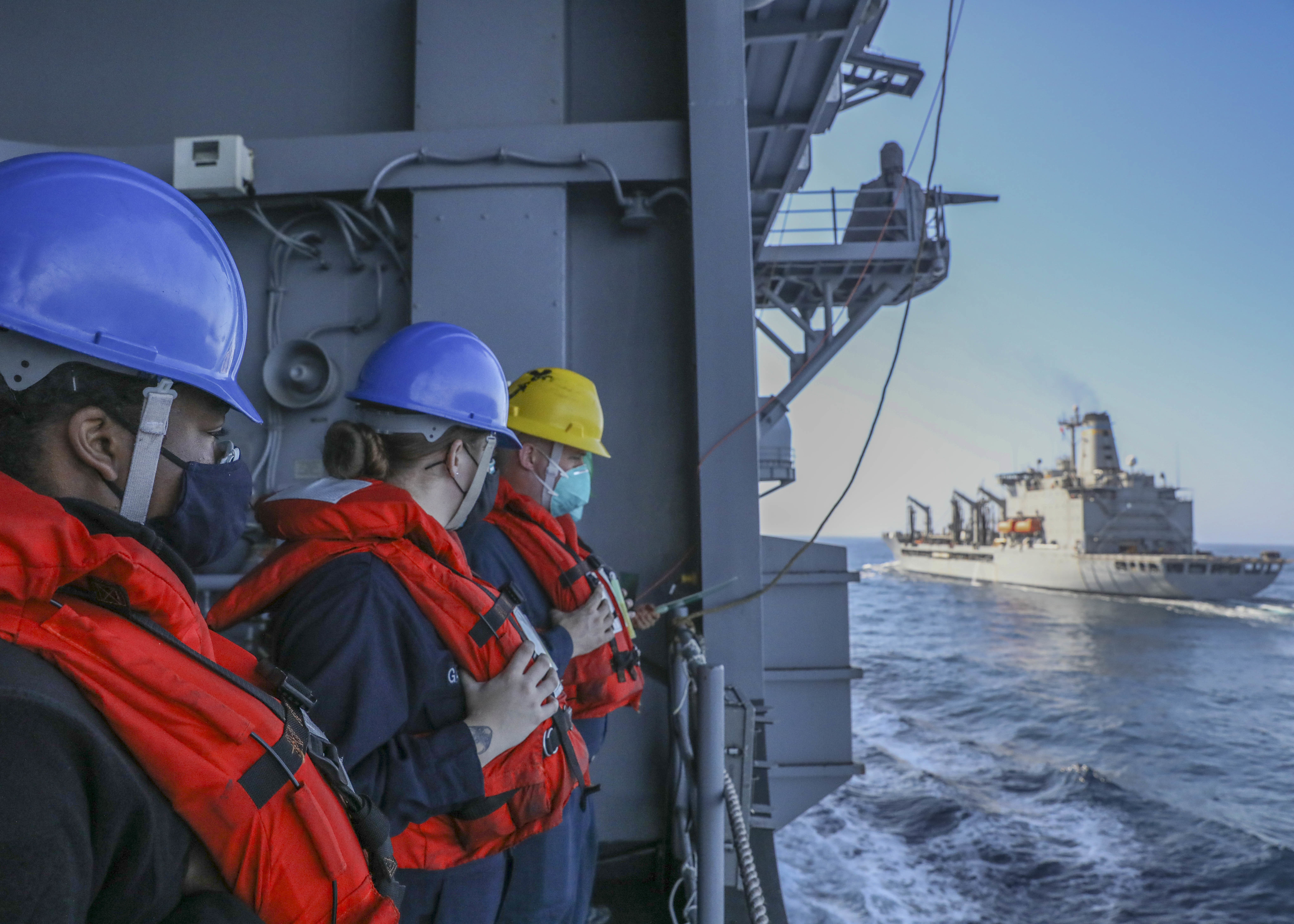 Boatswain's Mate 3rd Class Demonie Drawhorn, left, Boatswain's Mate 2nd Class Alyssa Garrett, middle, and Boatswain's Mate 1st Class Andrew Spears prepare for a replenishment at sea with USNS Guadalupe (T-AO 200) aboard the amphibious assault ship USS Makin Island (LHD 8).