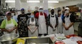 Members of the Alaska Air National Guard's 176th Force Support Flight Sustainment Services stand alongside the dedicated kitchen staff of Five Loaves, Two Fish Kitchen in Wasilla, Alaska, Sept. 22, 2020. “I have two extended families, my church and my military family,” said pastor Rick Cavens, retired Alaska Air National Guard chaplain who oversees the volunteer staff. “The National Guard has offered a tremendous helping hand during this difficult time of uncertainty. We’re very thankful for their hard work and dedication to helping the local community.” (U.S. Army National Guard photo by Sgt. Seth LaCount/Released)