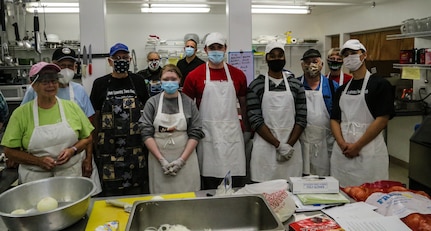 Members of the Alaska Air National Guard's 176th Force Support Flight Sustainment Services stand alongside the dedicated kitchen staff of Five Loaves, Two Fish Kitchen in Wasilla, Alaska, Sept. 22, 2020. “I have two extended families, my church and my military family,” said pastor Rick Cavens, retired Alaska Air National Guard chaplain who oversees the volunteer staff. “The National Guard has offered a tremendous helping hand during this difficult time of uncertainty. We’re very thankful for their hard work and dedication to helping the local community.” (U.S. Army National Guard photo by Sgt. Seth LaCount/Released)