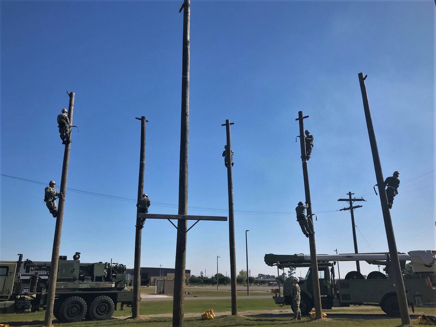 200415-N-N0443-0003 GULFPORT, Miss. (April 15, 2020) Construction Electrician C-1 Advanced Class 20020 staff and students maintain physical distancing during a pole climbing exercise at Naval Construction Training Center Gulfport, Mississippi, as they follow CDC guidelines to the extent applicable as part of the training center's proactive approach to combat COVID-19. Construction electricians build, maintain and operate power production facilities and electrical distribution systems for naval installations and support the Navy and Marine Corps operational and expeditionary forces worldwide. (U.S. Navy photo)