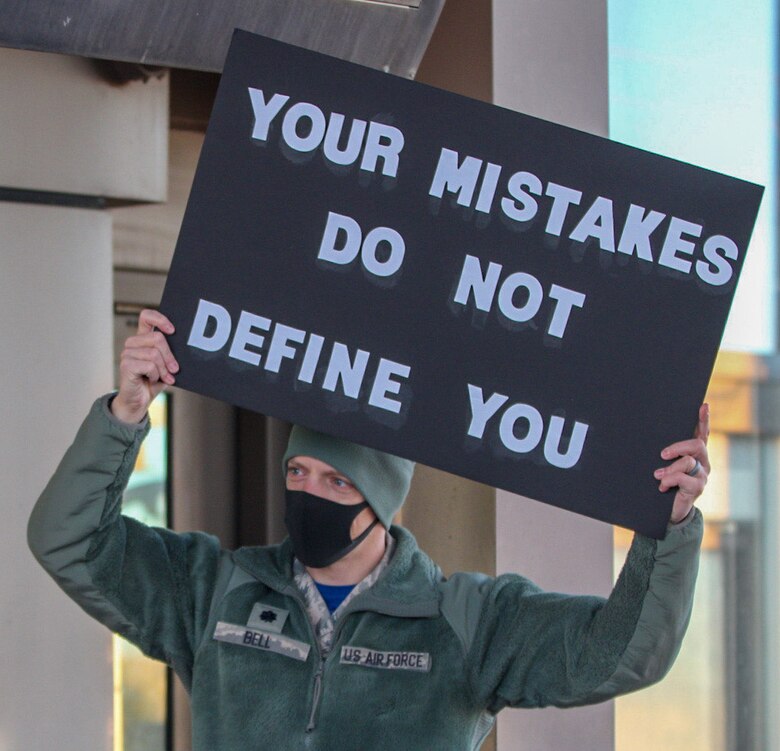 Lt. Col Bryan Bell, 1st Space Operations Squadron commander, displays his sign for users of the North gate to read Oct. 30, 2020, at Schriever Air Force Base, Colorado. Along with an encouraging message, Airmen and civilians received candy as they entered the gate for their duty day. (U.S. Space Force photo by Marcus Hill)