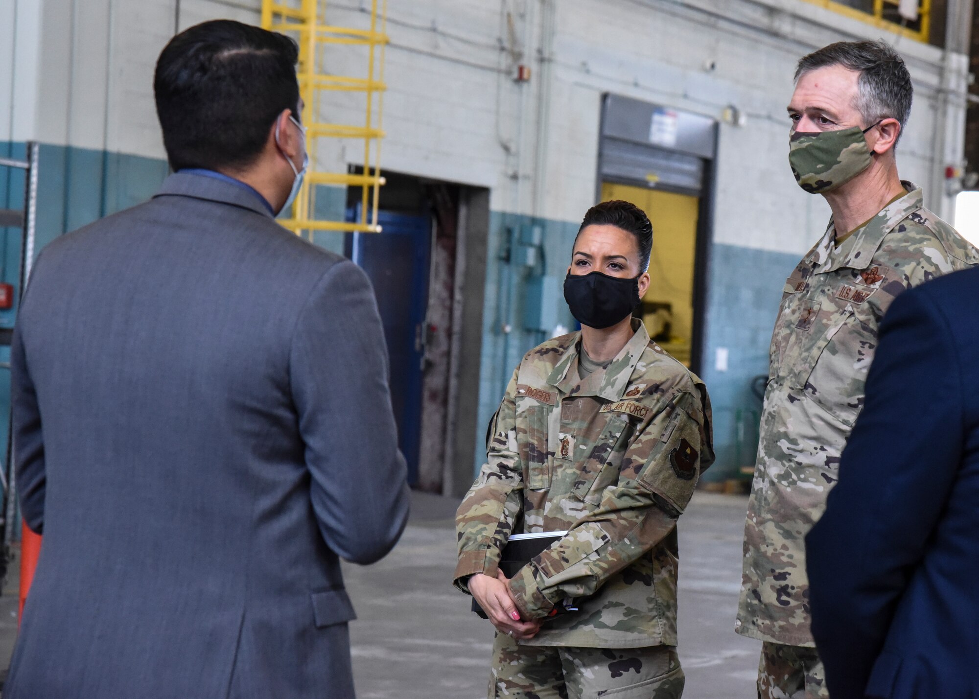 Contractor speaks to two Airmen.