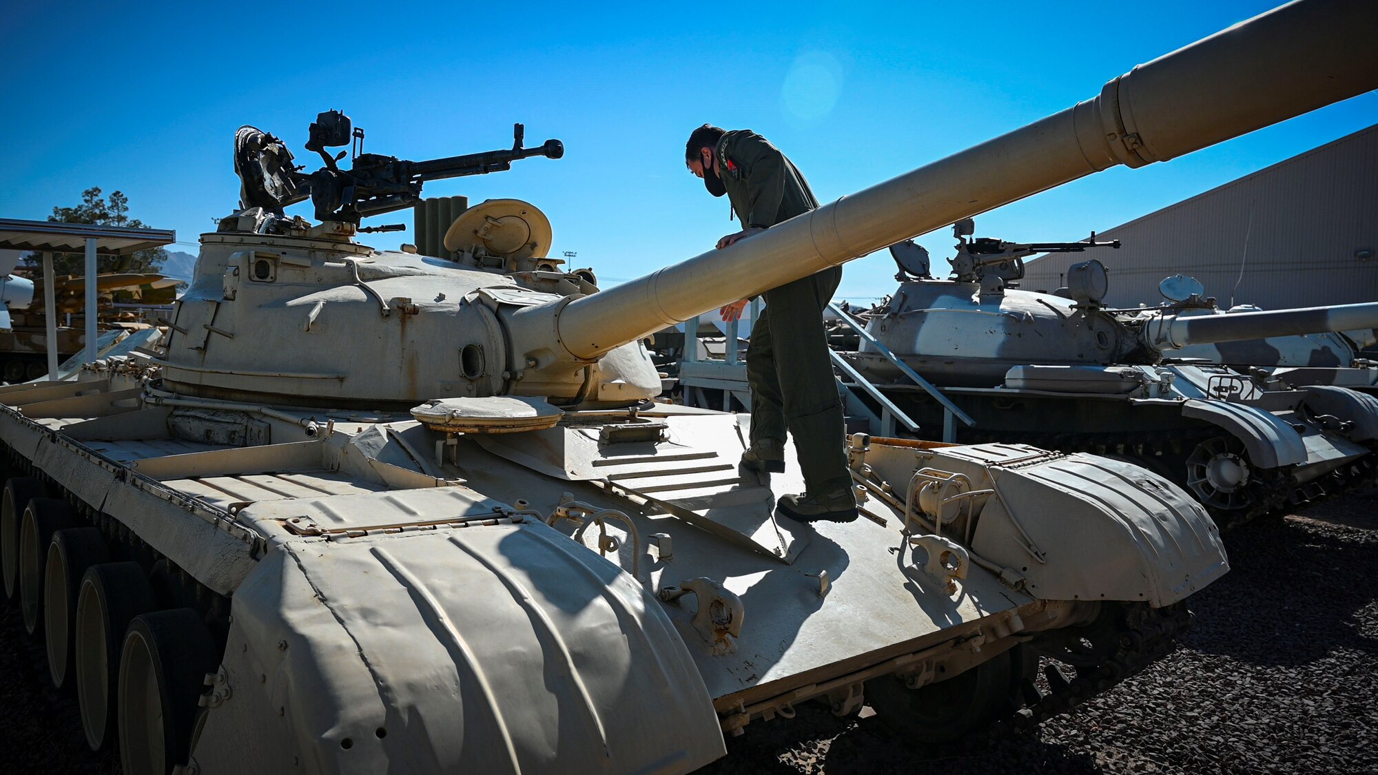 Foreign Liaison Officer climbs onto tank.