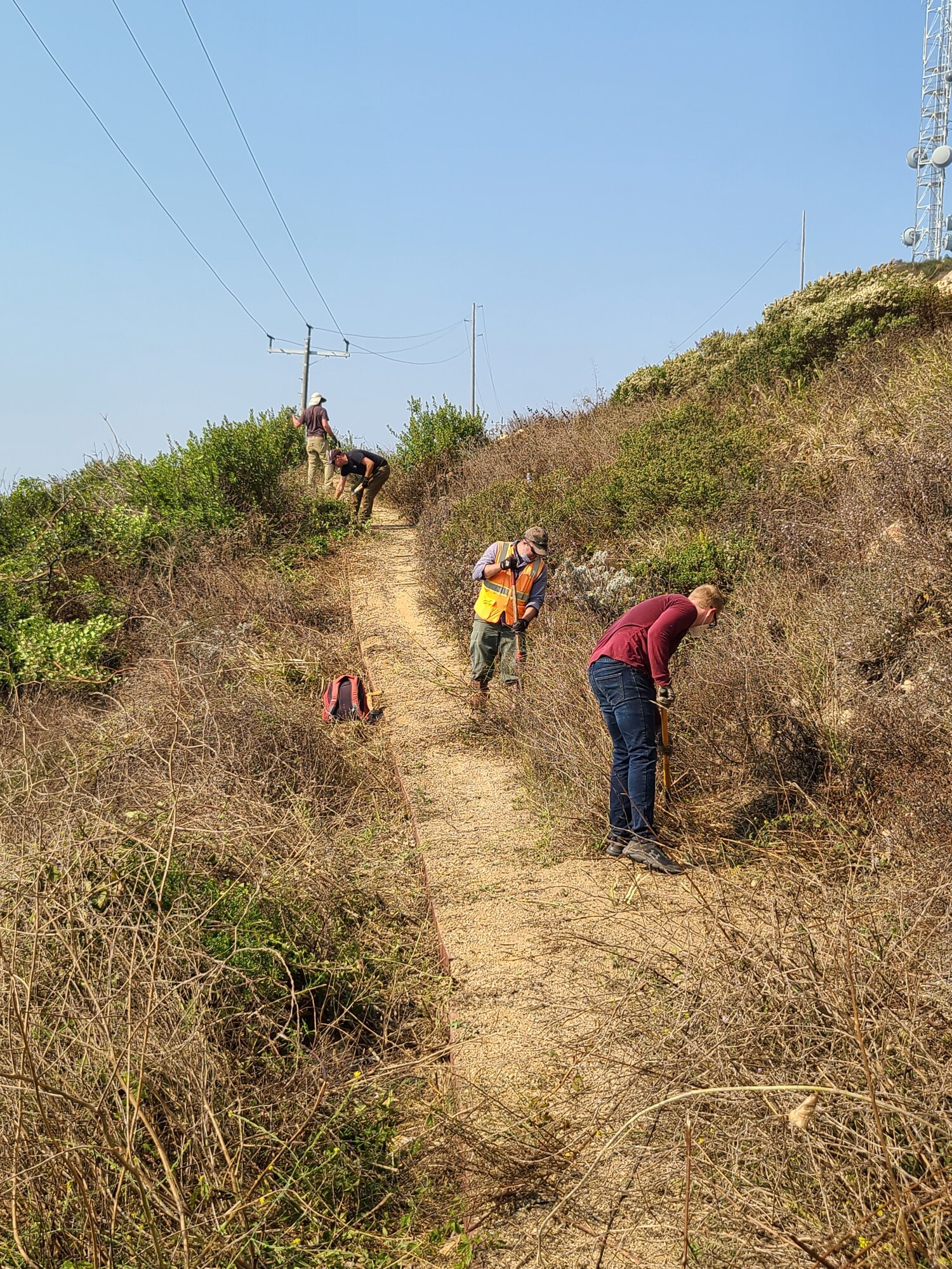 Volunteers clear vegetation at the Honda Ridge Rock Art Site trail during a National Public Lands Day cultural resource effort at Vandenberg Air Force Base, Calif. Seven volunteers came together to clear the path to the historic site to make it more accessible for viewers. The effort was part of the month-long list of volunteer events across base to include beach cleanups, invasive plant removal and a Boat House cleanup effort in support of National Public Lands Day.  (Courtesy photo)