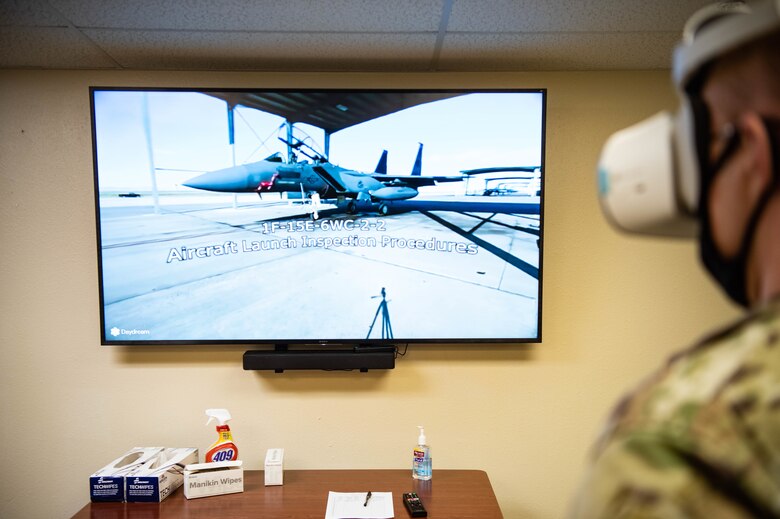 The 366th Operations Support Squadron demonstrates how to use the VR headset on Mountain Home Air Force Base, ID, Nov. 5, 2020. They are able to cast the headset video to the TV when multiple Airmen need the training. (U.S. Air Force photo by Airman 1st Class Cheyenne Bassham)