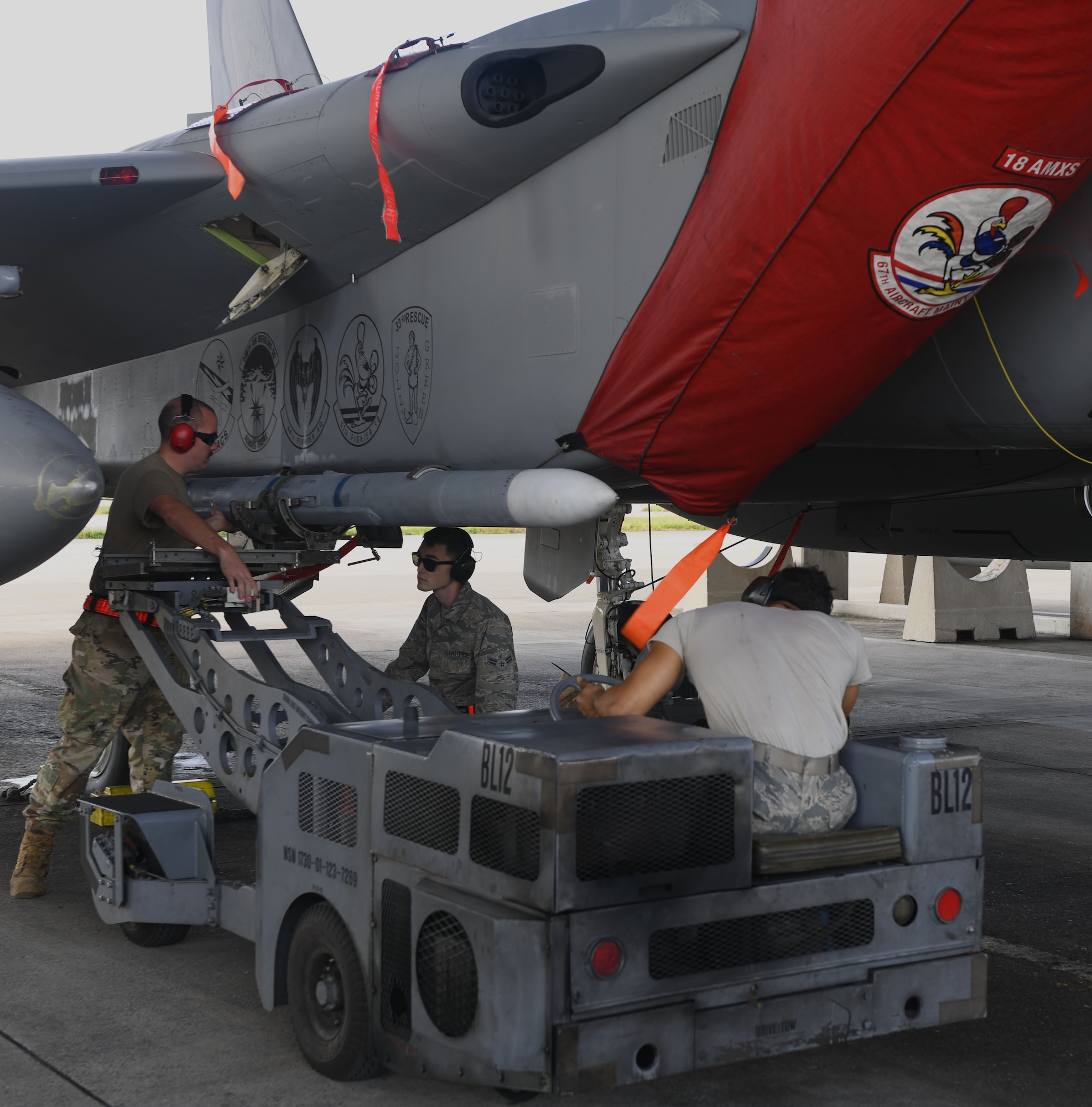 Airmen load a munition.