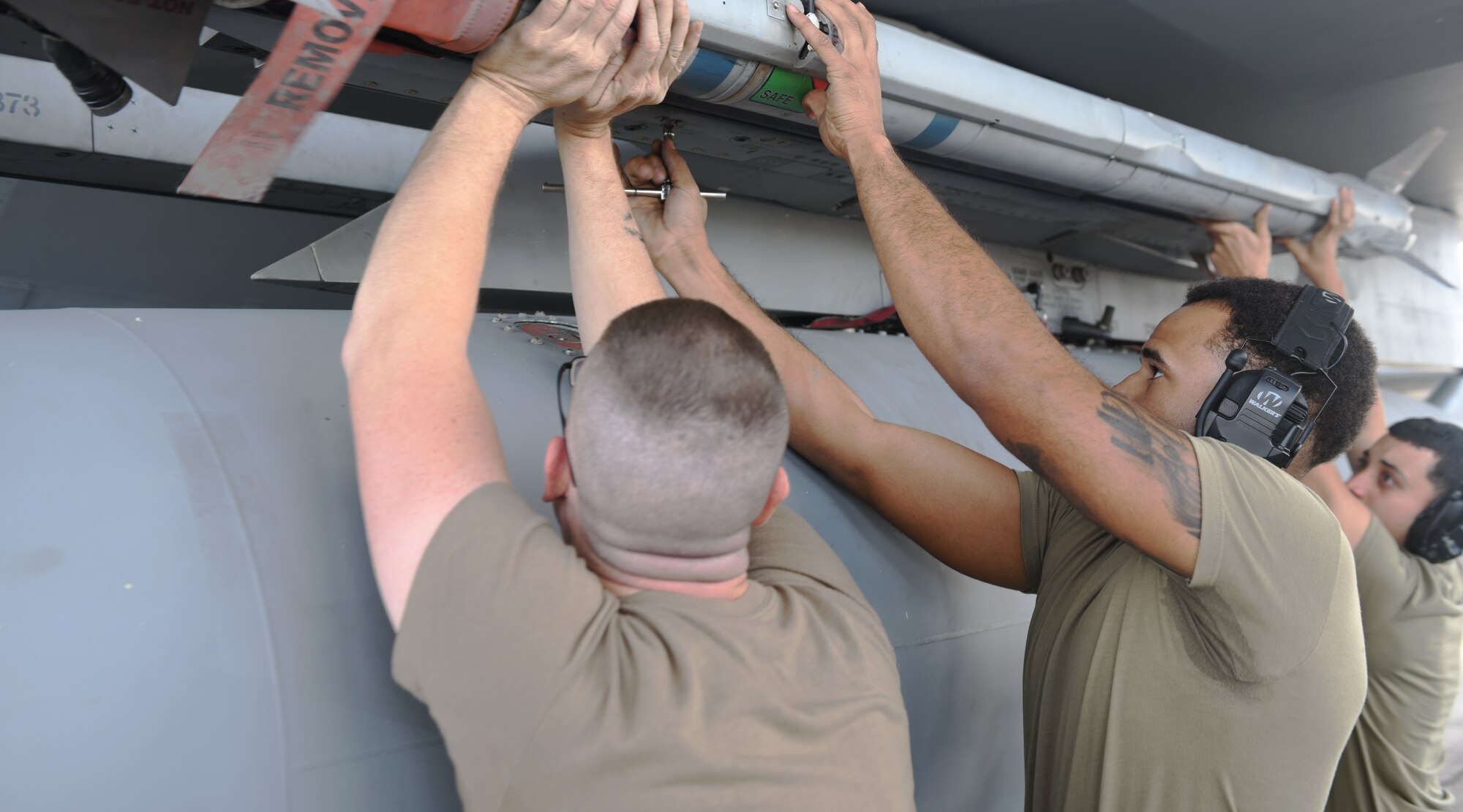 Airmen load a munition.