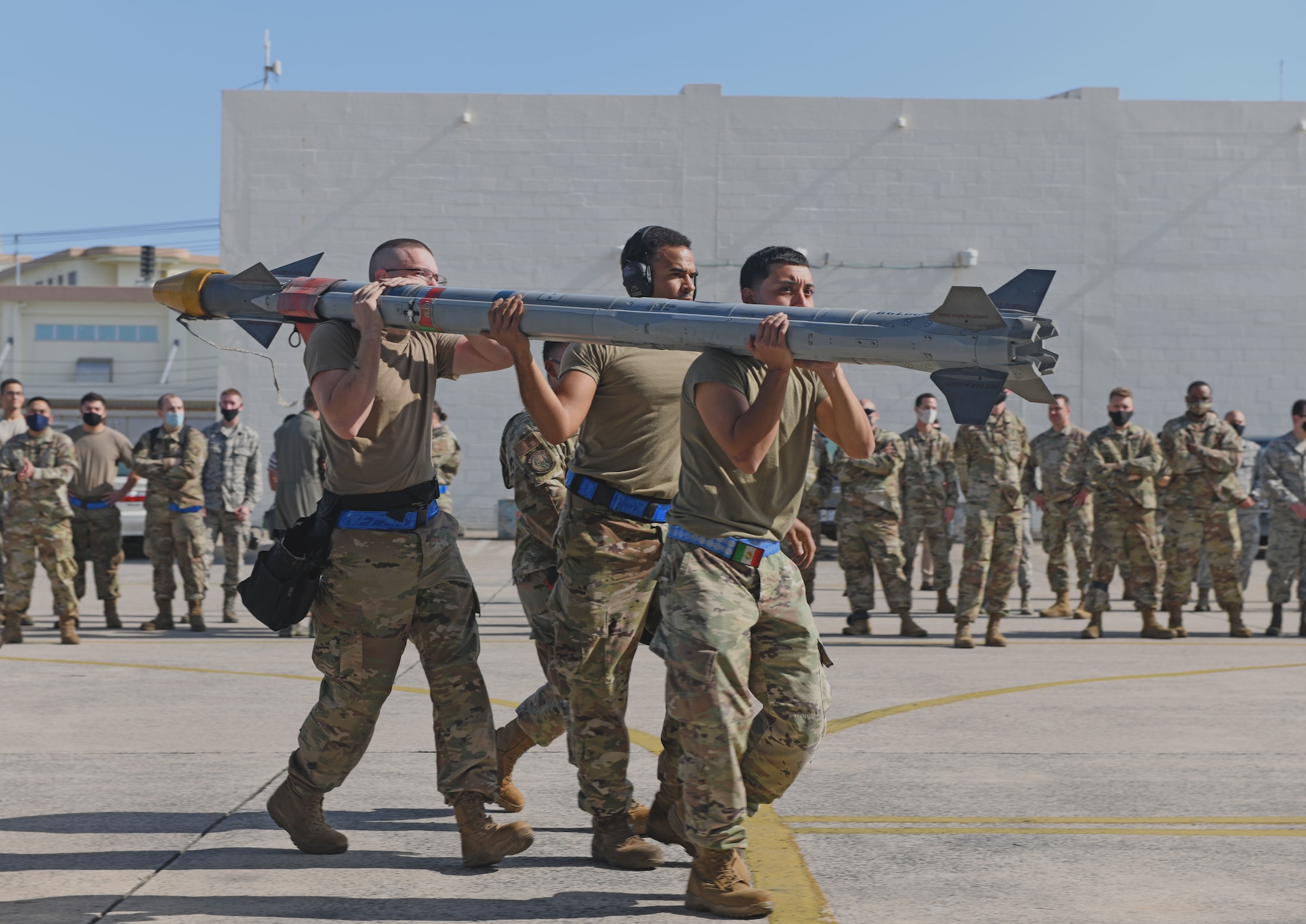 Airmen carry munition.