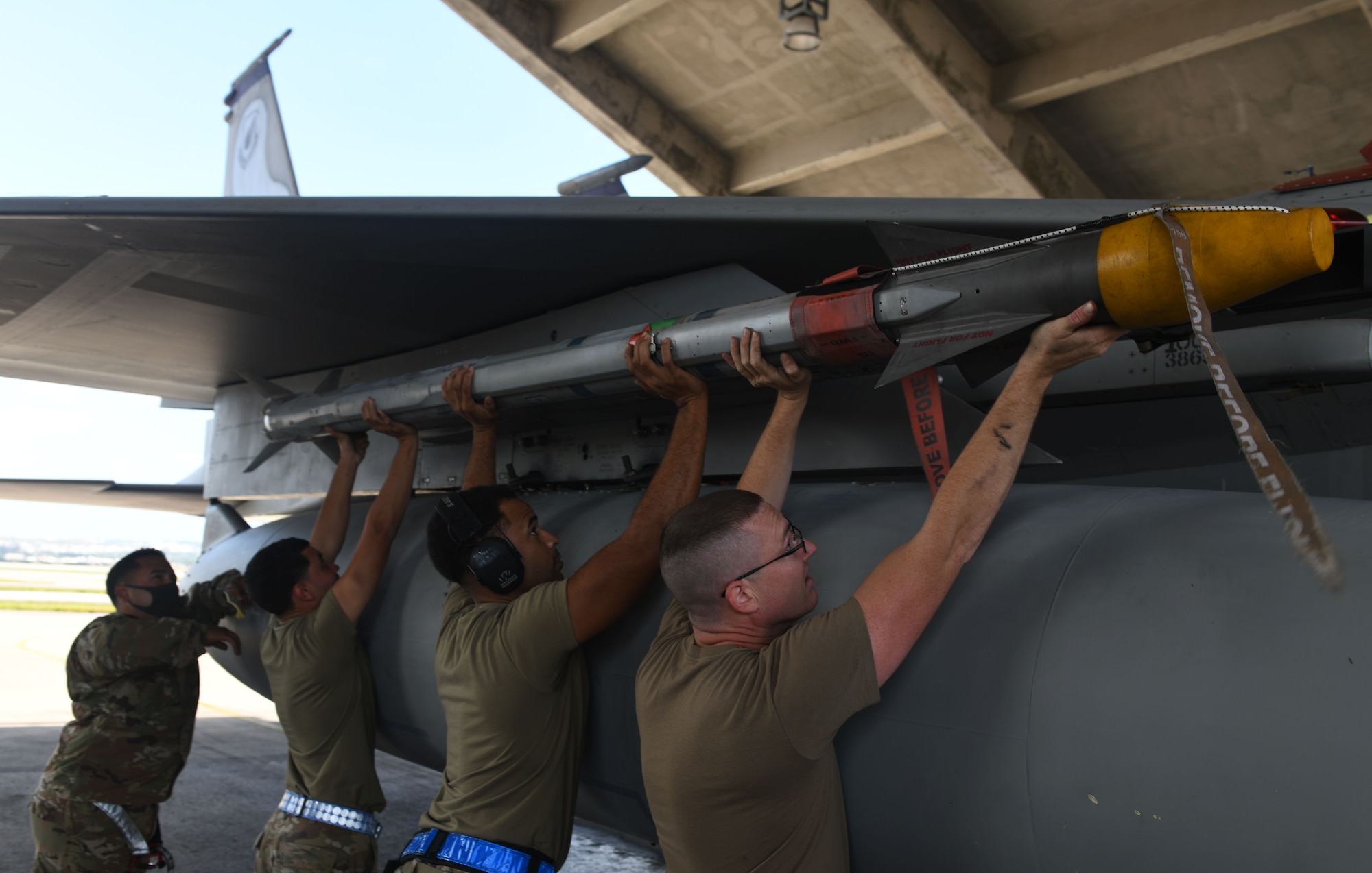 Airmen load a munition.