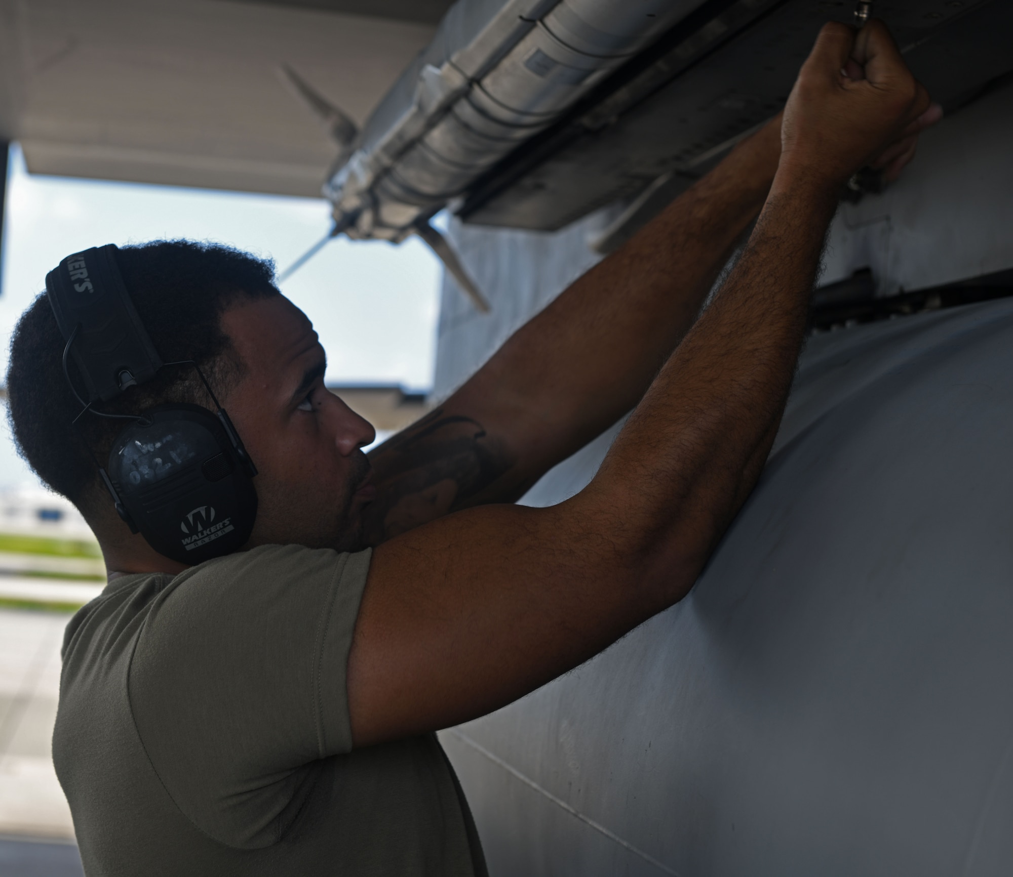 A maintainer tightens bolts.