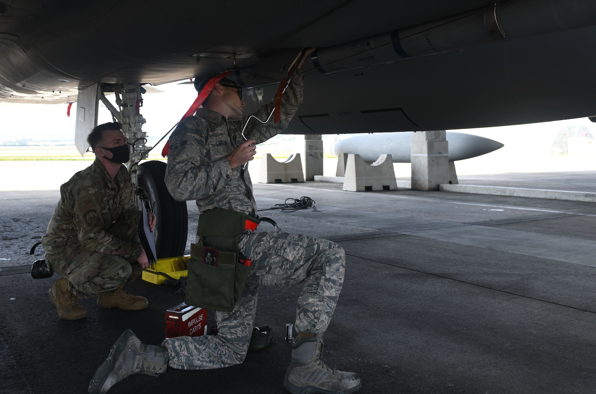 Airman works under a fighter jet.