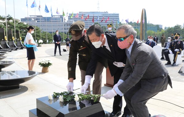 Gen. Robert B. “Abe” Abrams, commander of United Nations Command, ROK-US Combined Forces Command, and United States Forces Korea, U.S. Ambassador to Korea Harry Harris, and Korean American Friendship Society director Hwang Jin Ha place a flower at the stone base of the U.N. Memorial as a tribute to service members who paid the ultimate sacrifice during the Korean War.