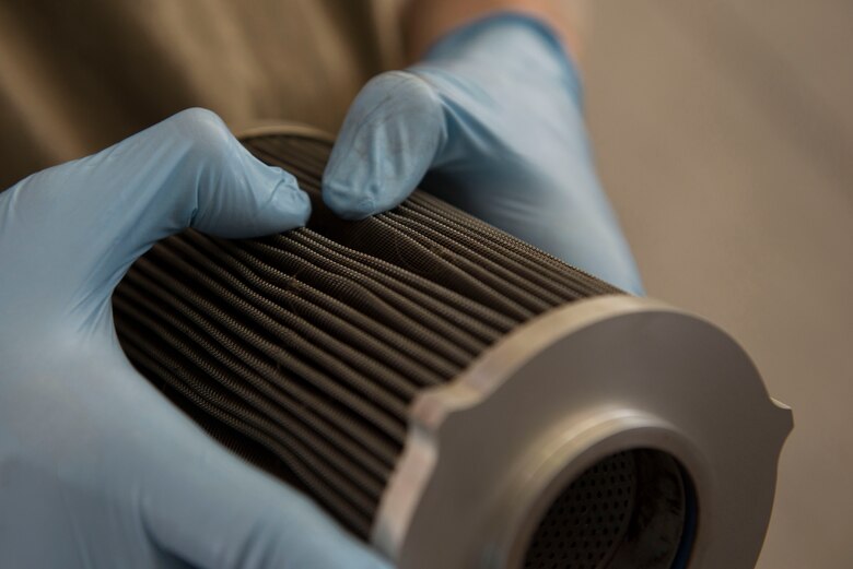 U.S. Air Force Airman 1st Class Trey Trimble, 380th Expeditionary Aircraft Maintenance Squadron crew chief, inspects a used fuel filter following removal from an RQ-4 Global Hawk unmanned aerial vehicle at Al Dhafra Air Base, United Arab Emirates, Nov. 3, 2020.
