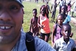 An airman takes a selfie with children.