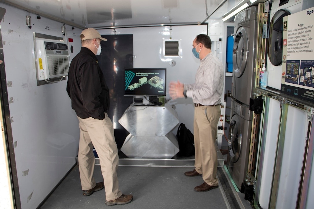 U.S. Army Engineer Research and Development Center (ERDC), Construction Engineering Research Laboratory (CERL), material engineer and Operational Water project lead Dr. Martin Page briefs the Principal Deputy Assistant Secretary of the Army for Installations, Energy and Environment Bryan Gossage at the ERDC Forward Operating Base-Laboratory in Champaign, Ill., Oct. 30, 2020. Page explained the difficulties that deployed service members have with sustaining clean drinking water and water used for showers or laundry facilities. The CERL team, with collaboration with industry partners, has developed several water treatment and reuse technologies and systems to turn gray and black water into a new potable or near-potable water source.