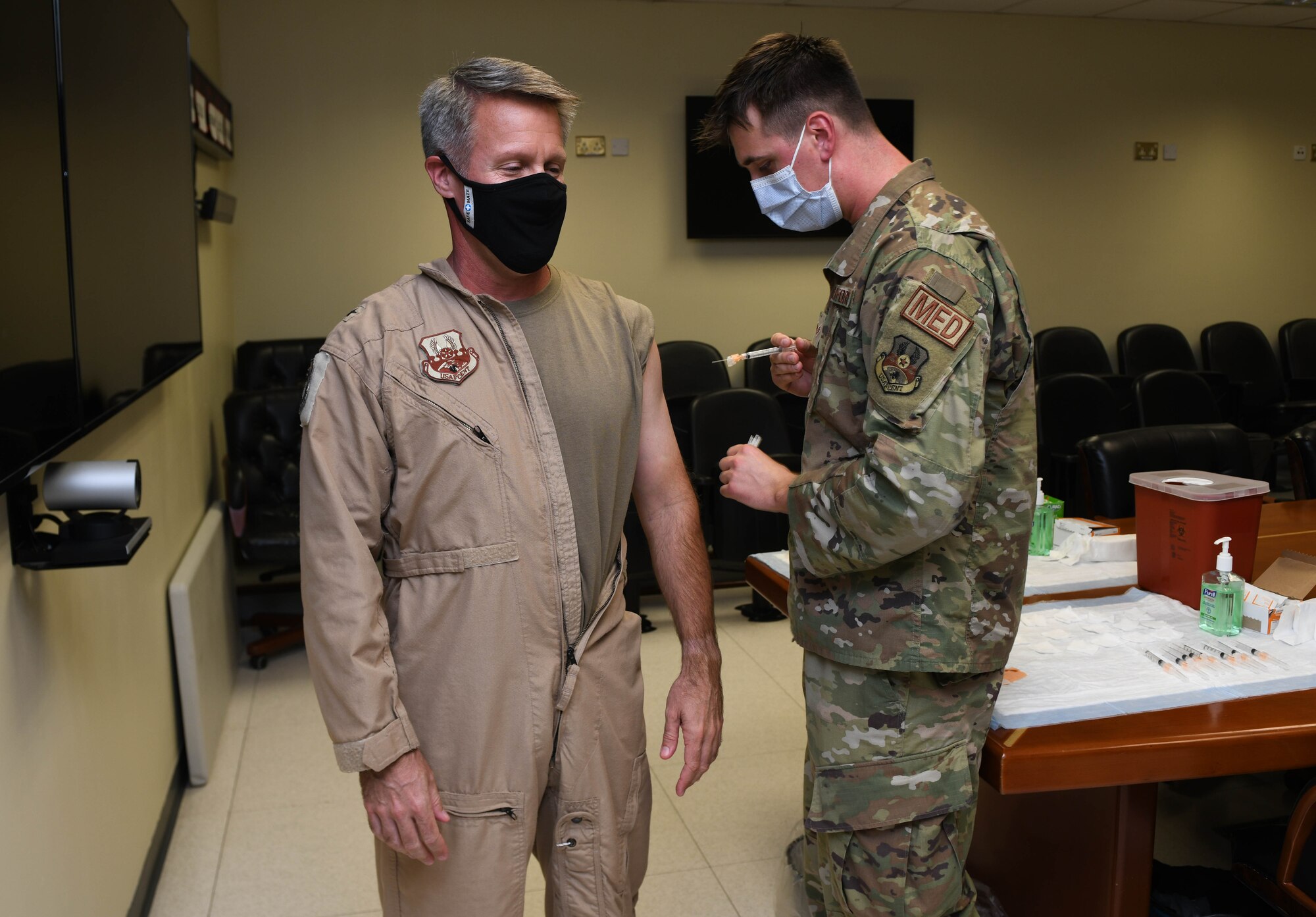 Senior Airman Joshua Zahn, medical technician with the 379th Expeditionary Medical Group, administers the flu vaccine to the 379th Air Expeditionary Wing Commander, Brig. Gen. Dan Tulley, at Al Udeid Air Base, Qatar, Nov. 3, 2020. Zahn, the acting NCO in charge of the allergy and immunization section, offered vaccinations in numerous work centers throughout the wing significantly improving the unit’s mission readiness by preparing service members for the upcoming flu season while preventing confusion between COVID-19 and seasonal flu symptoms.  (U.S. Air Force photo by Staff Sgt. Kayla White)