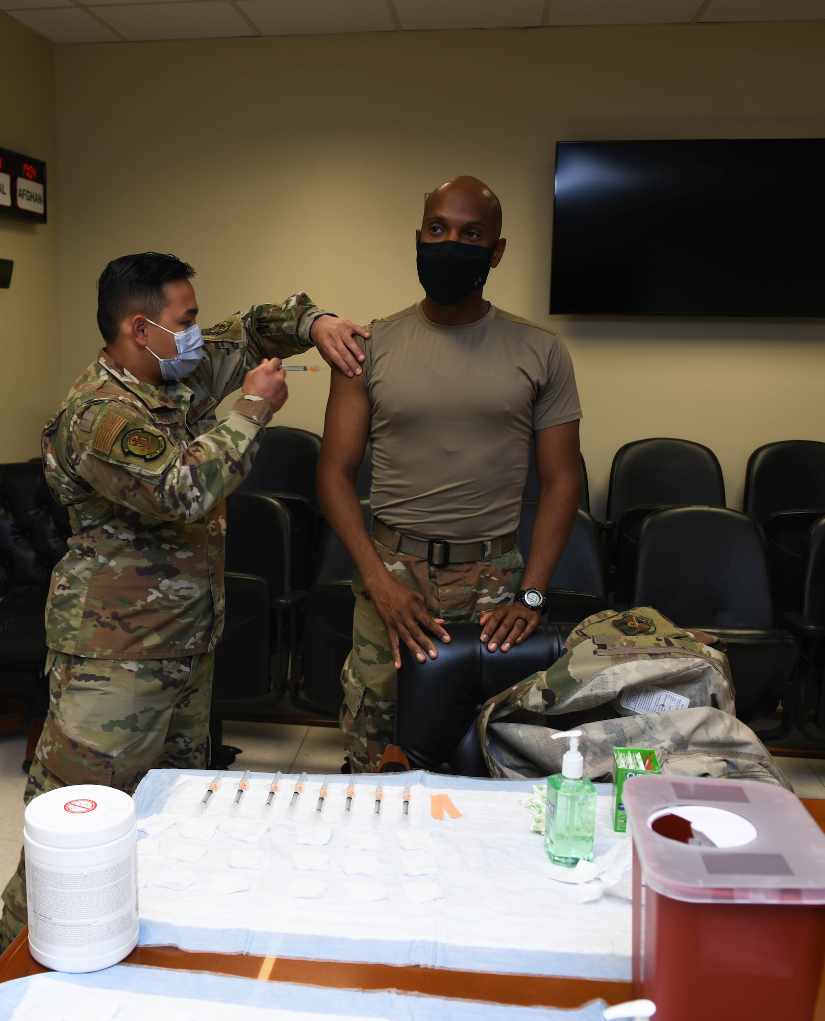 Staff Sgt. Jake Quichocho, assigned to the 379th Expeditionary Medical Group, administers the flu vaccine to the 379th Air Expeditionary Wing Command Chief, Chief Master Sgt. Kenneth Bruce, at Al Udeid Air Base, Qatar, on Nov. 3, 2020. Senior Airman Joshua Zahn, the acting NCO in charge of the allergy and immunization section, offered vaccinations in numerous work centers throughout the wing significantly improving the unit’s mission readiness by preparing service members for the upcoming flu season while preventing confusion between COVID-19 and seasonal flu symptoms. (U.S. Air Force photo by Staff Sgt. Kayla White)