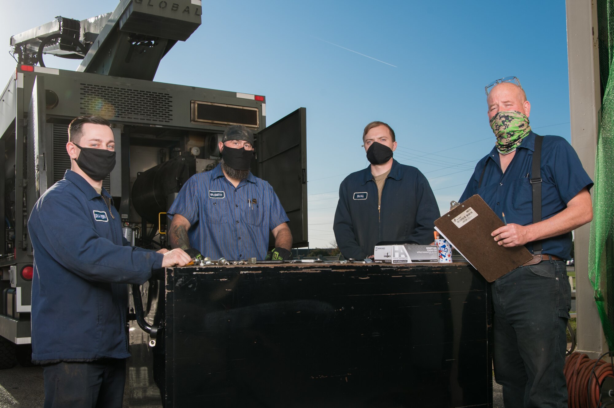 (From left) Senior Airman Anthony Rein, 436th Logistics Readiness Squadron mission generation vehicle and equipment journeyman, Christopher Smith, 436th LRS heavy equipment mobile mechanic, Senior Airman Taylor Hall, 436th LRS mission generation vehicle and equipment journeyman, and Gary Eley, 436th LRS Multipurpose Maintenance shop supervisor prepare for the start of their workday Oct. 22, 2020, at Dover Air Force Base, Delaware. The combined staff of Airmen and civilians are responsible for maintaining a fleet of almost 180 vehicles. (U.S. Air Force photo by Mauricio Campino)