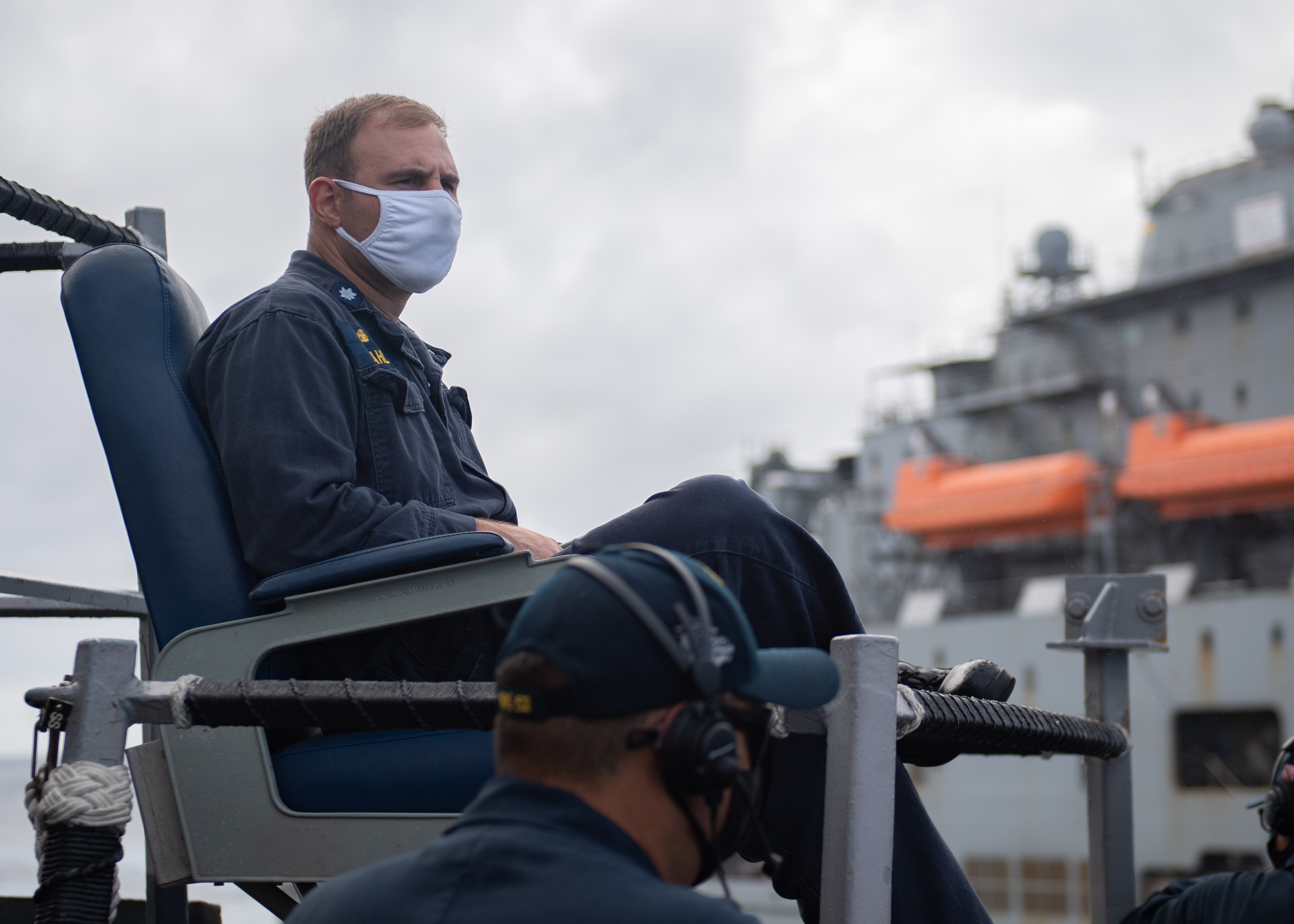 Cmdr. Christopher Gahl sits on the bridge wing of USS Barry (DDG 52)  during a replenishment-at-sea with USNS Alan Shephard (T-AKE 3).