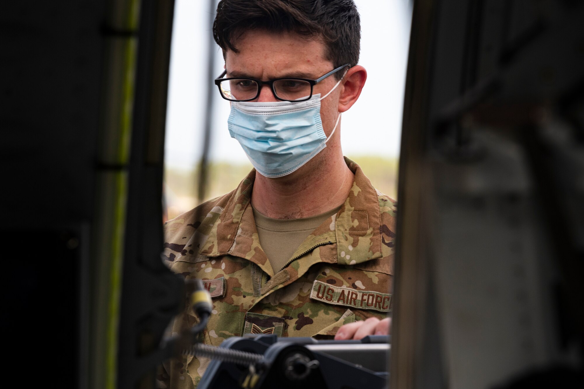 A photo of an Airman inspecting a weapon