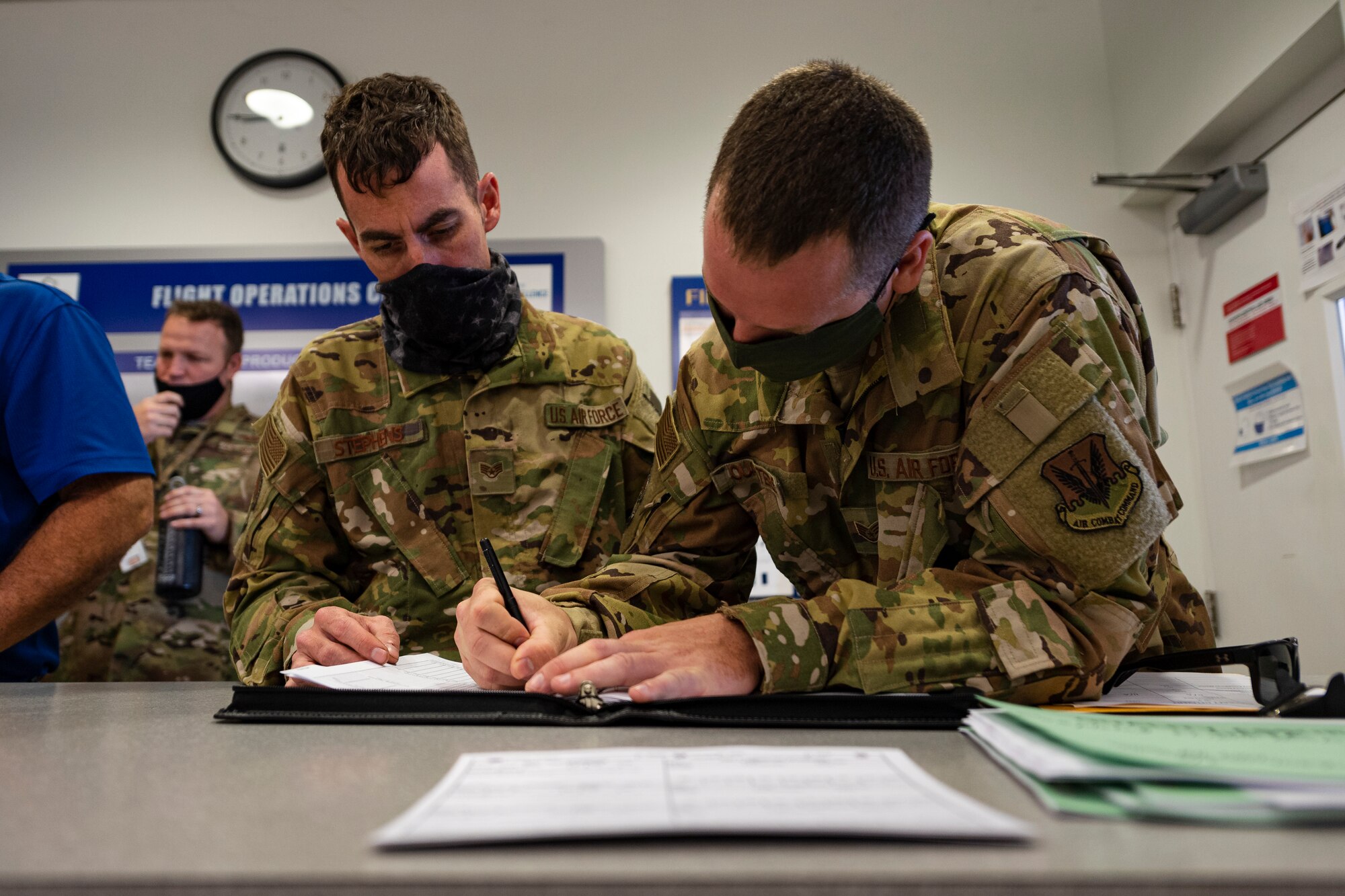 A photo of Airmen checking forms