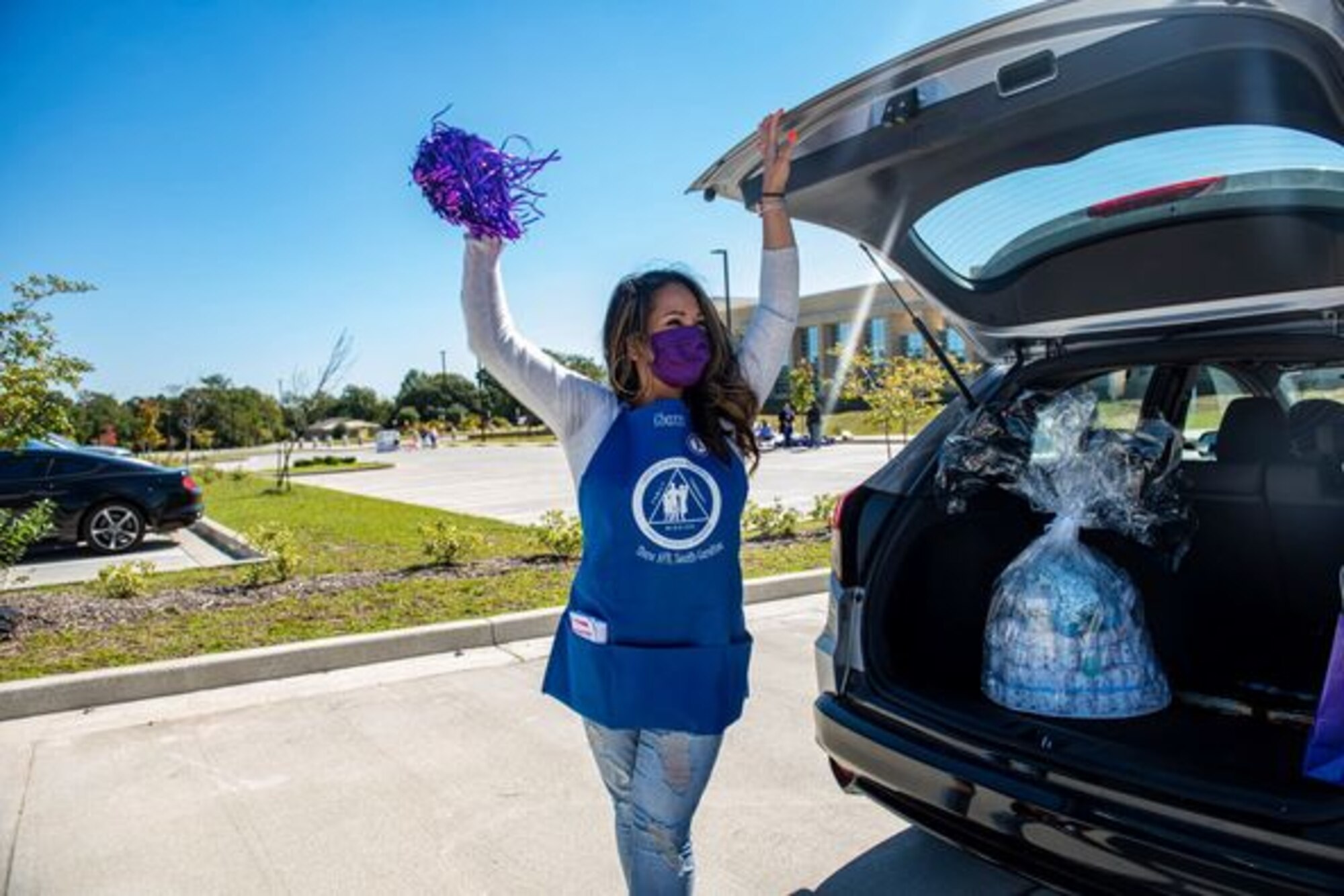 A New Parent Support Program volunteer stands outside a vehicle.