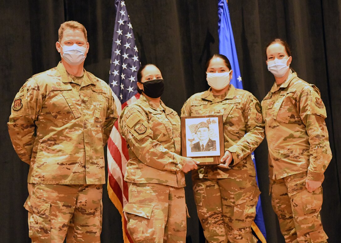 Colonel Peter Bonetti, 90th Missile Wing Commander, and Command Chief Master Sgt. Tiffany Bettisworth, present an Airman Leadership School graduate with a certificate Nov. 5 at the Base Theater on F. E. Warren Air Force Base, Wyo.