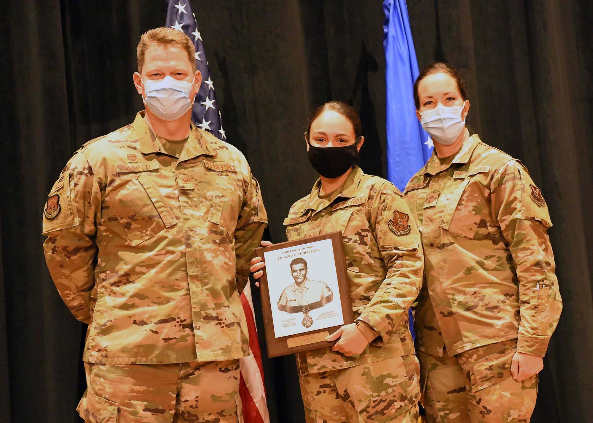 Colonel Peter Bonetti, 90th Missile Wing Commander, and Command Chief Master Sgt. Tiffany Bettisworth, present an Airman Leadership School graduate with a certificate Nov. 5 at the Base Theater on F. E. Warren Air Force Base, Wyo.