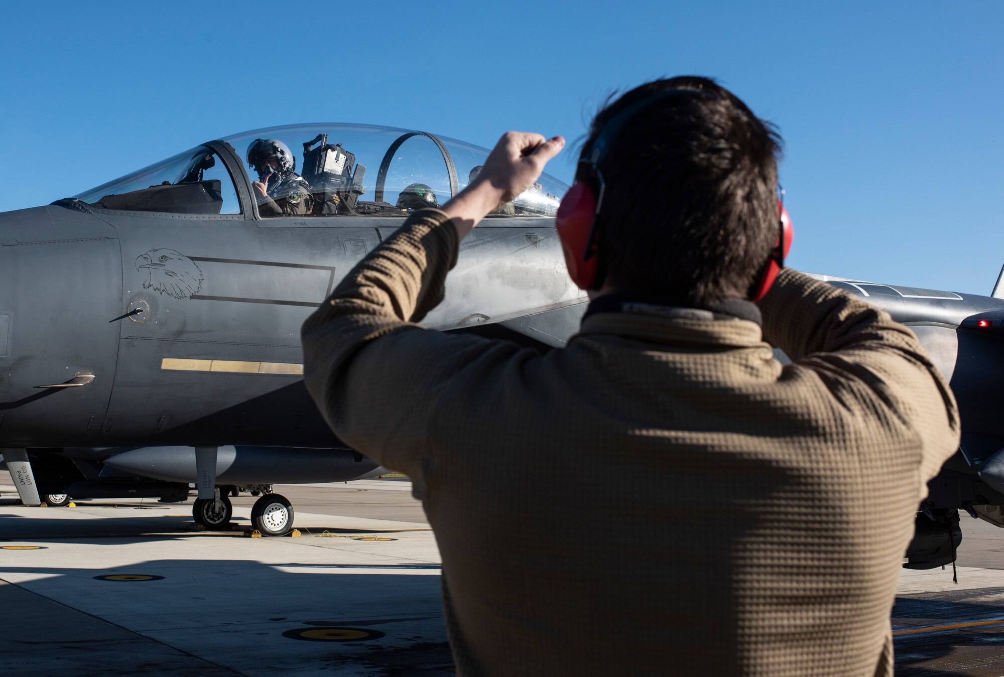 A crew chief assigned to the 48th Aircraft Maintenance Unit marshalls an F-15E Strike Eagle onto the apron after a training sortie in support of exercise Crimson Warrior at Royal Air Force Lakenheath, England, Nov. 6, 2020. Multi-domain integration exercises like Crimson Warrior strengthen NATO interoperability and test high-end capabilities in a contested, degraded, and operationally limited environment. (U.S. Air Force photo by Airman 1st Class Jessi Monte)