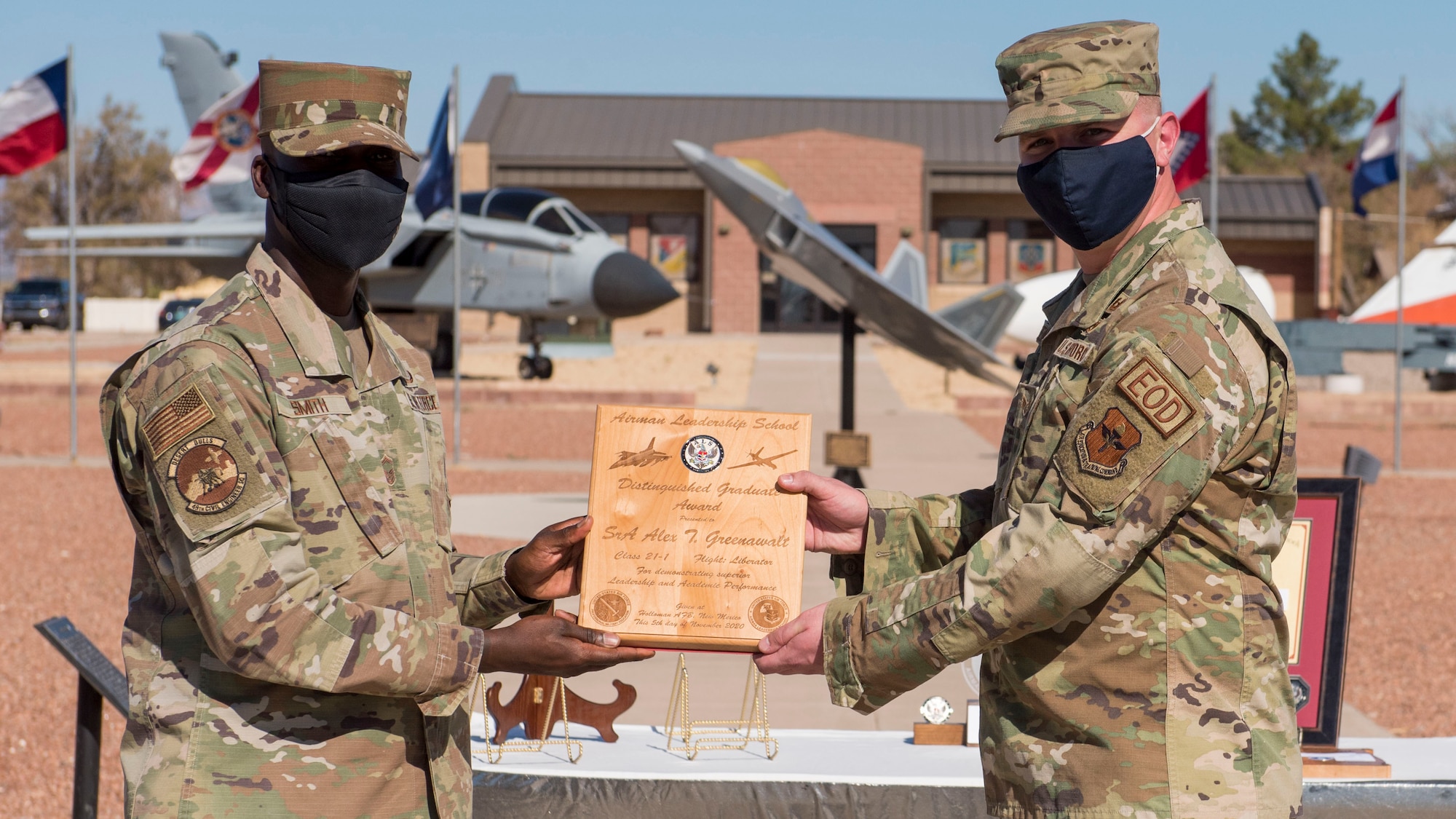Senior Airman Alex Greenwalt, right, Airman Leadership School graduate, accepts the distinguished graduate award during the graduation of ALS class 21-1, Nov. 5, 2020, on Holloman Air Force Base, New Mexico. The distinguished graduate award is presented to the top ten-percent of graduates for their performance in academic evaluations and demonstration of leadership. (U.S. Air Force photo by Staff Sgt. Christine Groening)