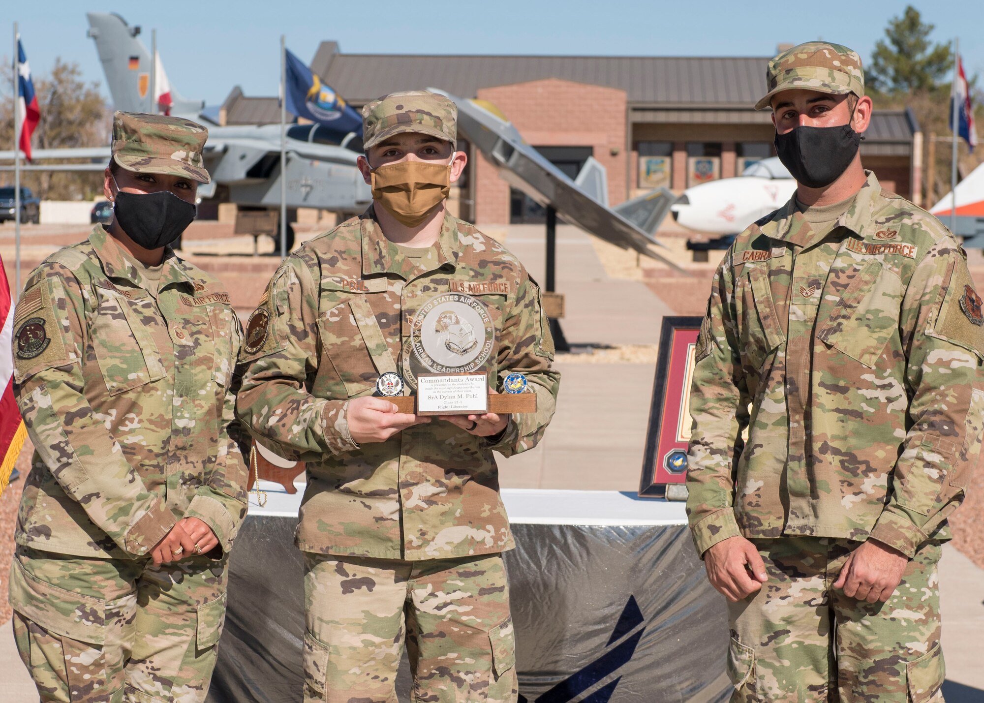 Senior Airman Dylan Pohl, center, Airman Leadership School graduate, accepts the commandant leadership award during the graduation of ALS class 21-1, Nov. 5, 2020, on Holloman Air Force Base, New Mexico. The commandant leadership award is selected by the ALS commandant and is presented to the student who demonstrates exemplary leadership characteristics. (U.S. Air Force photo by Staff Sgt. Christine Groening)