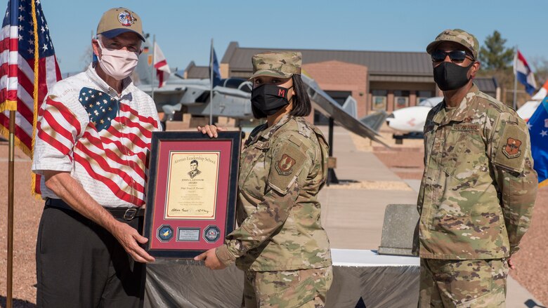 Staff Sgt. Tracy Turner, center, Airman Leadership School graduate, accepts the John L. Levitow award during the graduation of ALS class 21-1, Nov. 5, 2020, on Holloman Air Force Base, New Mexico. The John L. Levitow award is presented to the student demonstrating the highest level of leadership and scholastic performance, and is determined by the assignment of points by their peers. (U.S. Air Force photo by Staff Sgt. Christine Groening)