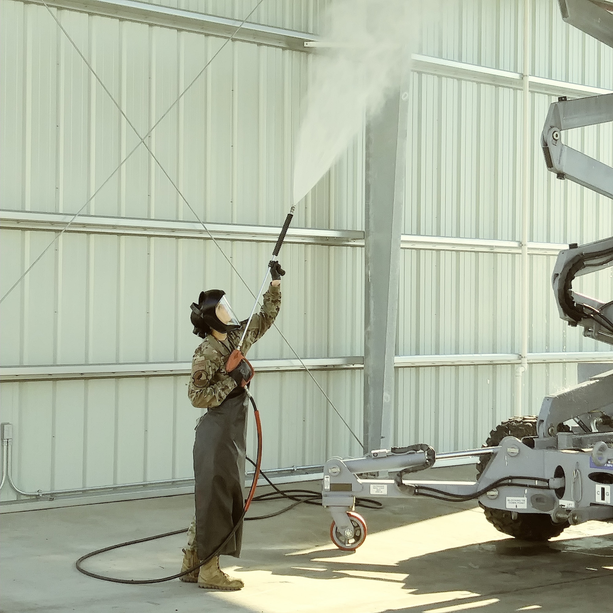 Senior Airman Shawna L. Gaither, 940 MXS Air Reserve Technician, adorns protective equipment as she does a pressure wash in the rack on the UMS.