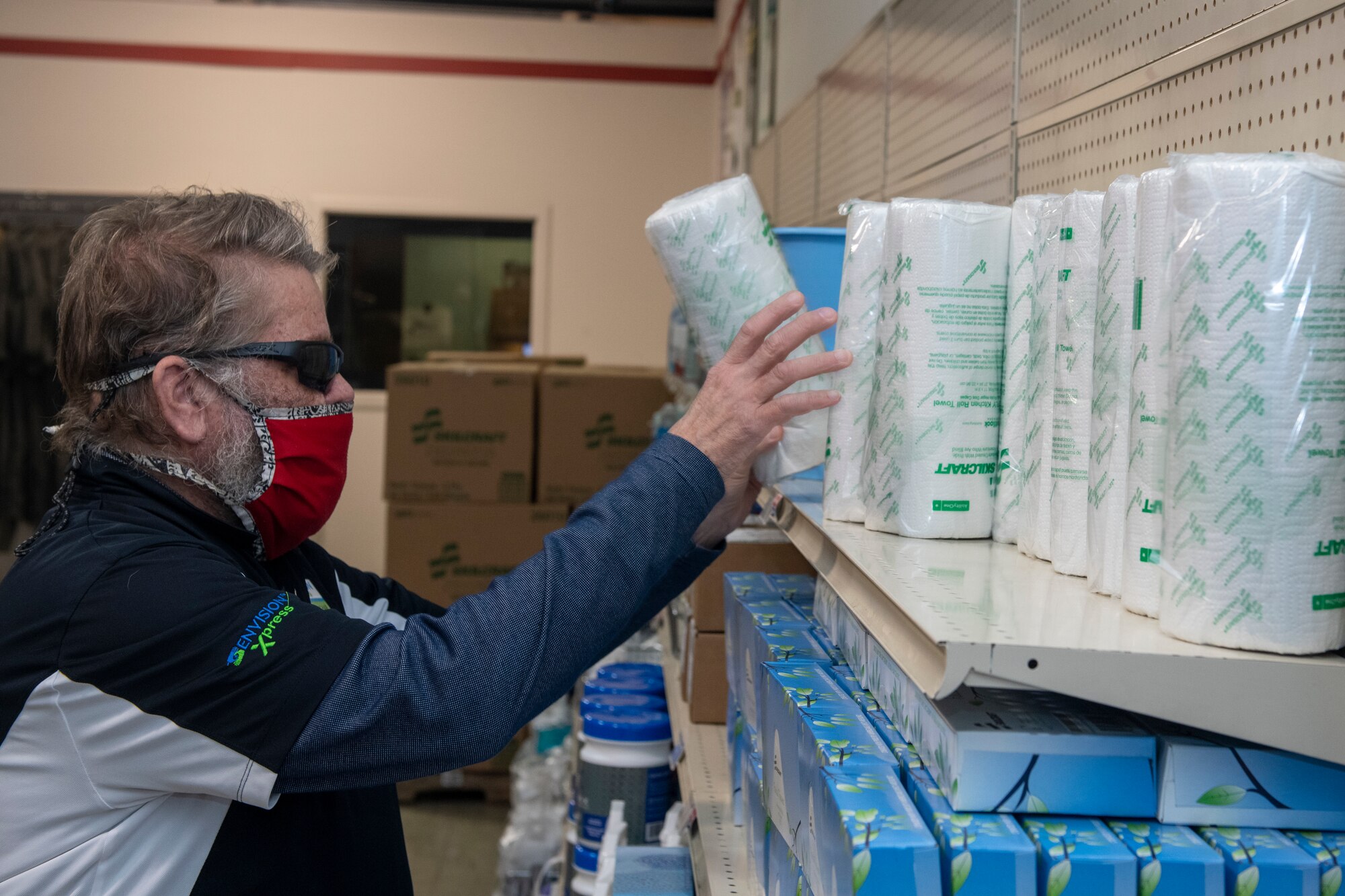 Man puts paper towels on shelf