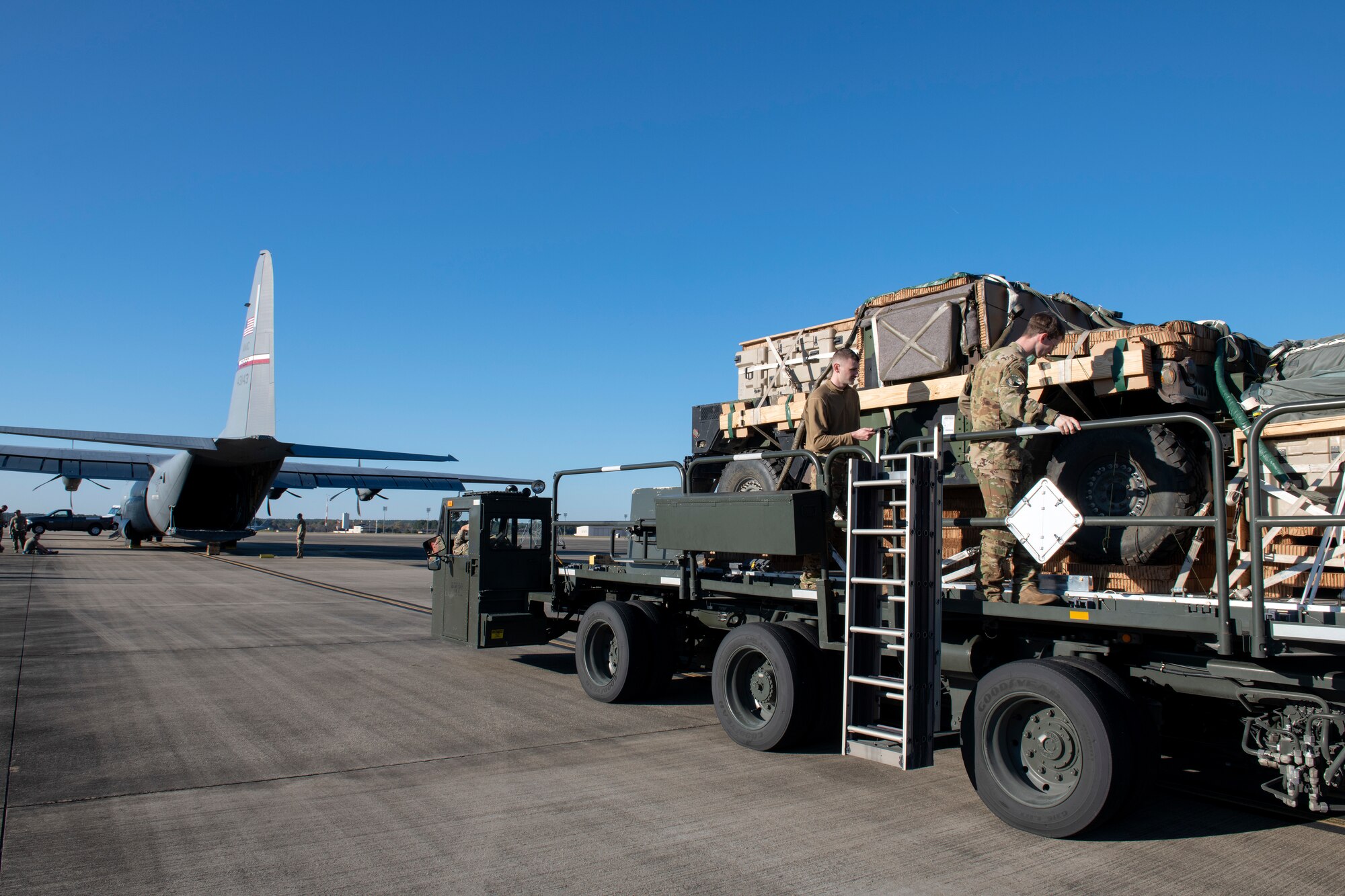 large truck being inspected at rear of plane